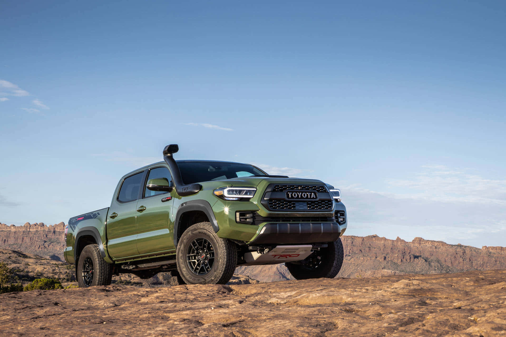 Pickup Truck 桌布 壁紙 — 一架堅固的橄欖綠色豐田 Tacoma TRD Pro 在晴朗藍天下屹立於岩石沙漠地形上。