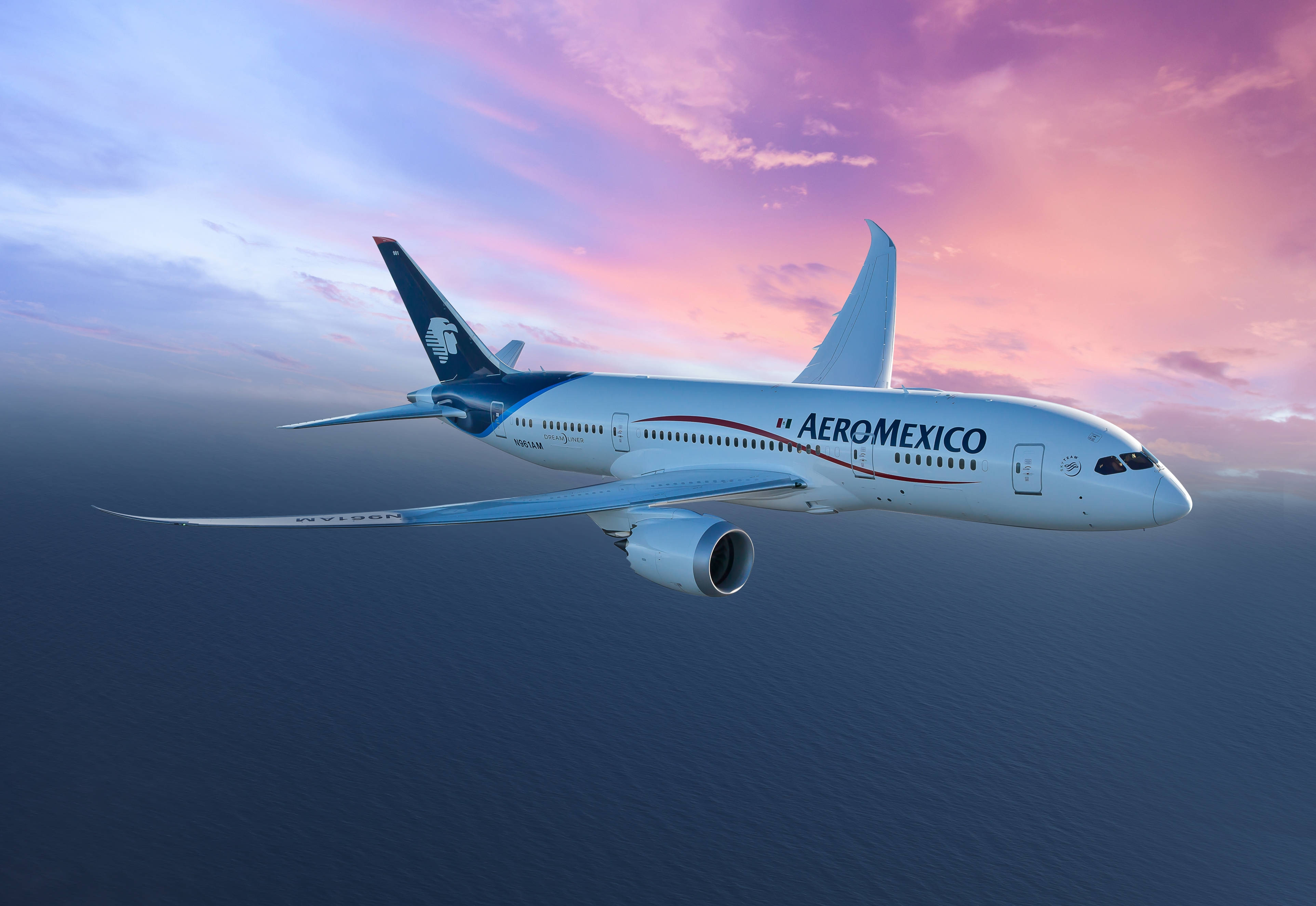 Plane 桌布 壁紙 — 一架墨西哥航空波音787在深藍色海洋上空優雅翱翔，背景是充滿活力的粉紅與紫色日落天空。