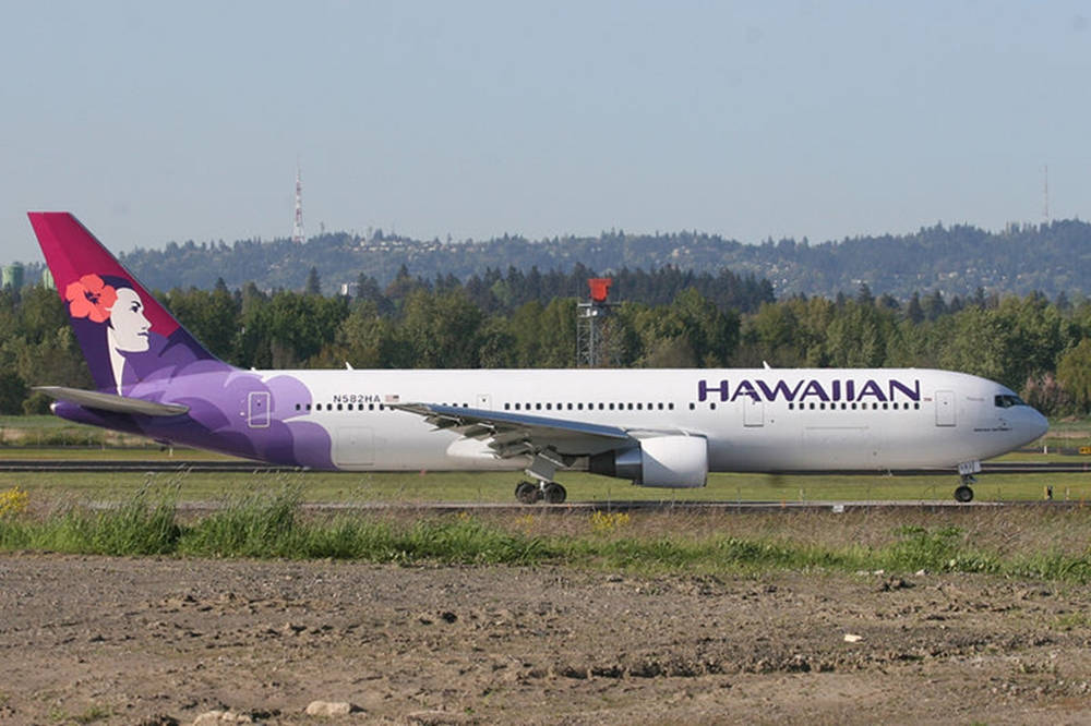 夏威夷航空飛機在跑道上，帶有紫色和粉紅色花卉設計