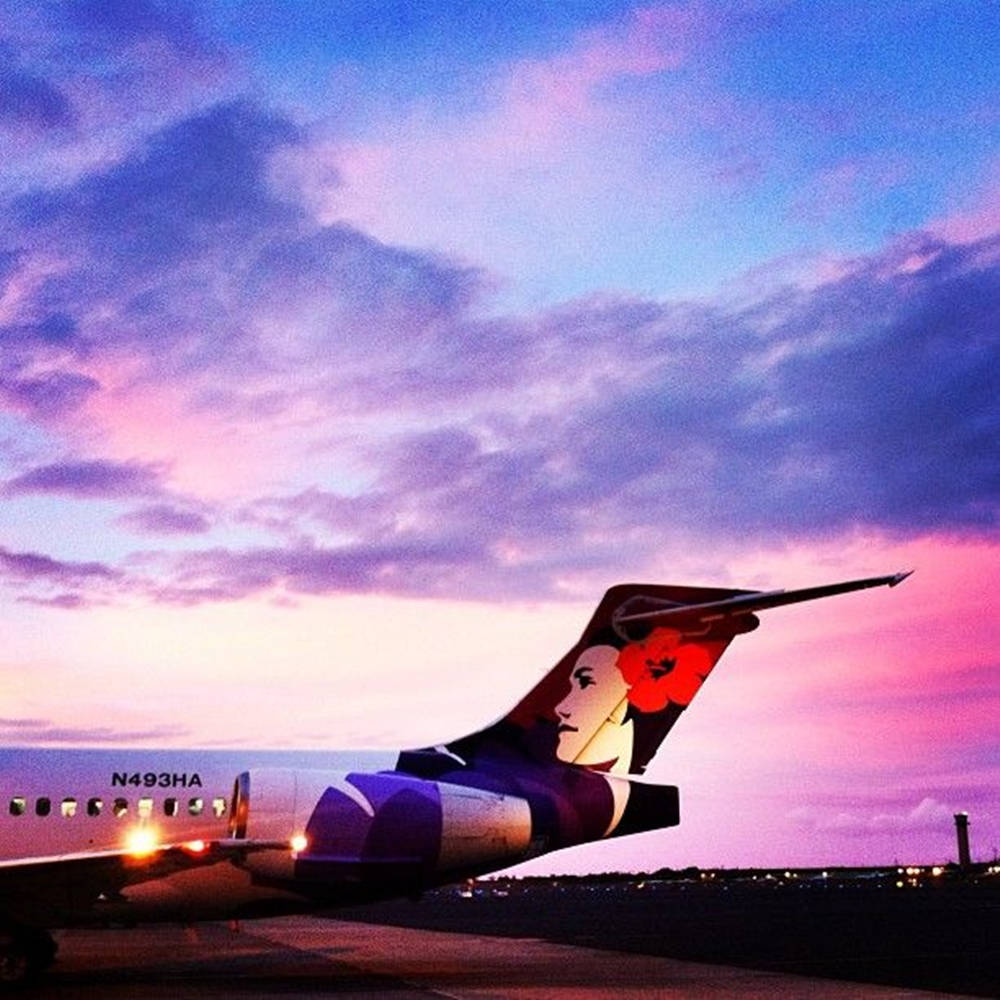 夏威夷航空飛機在日落時分停在跑道上，天空呈現粉紫色 — 夏威夷 壁紙