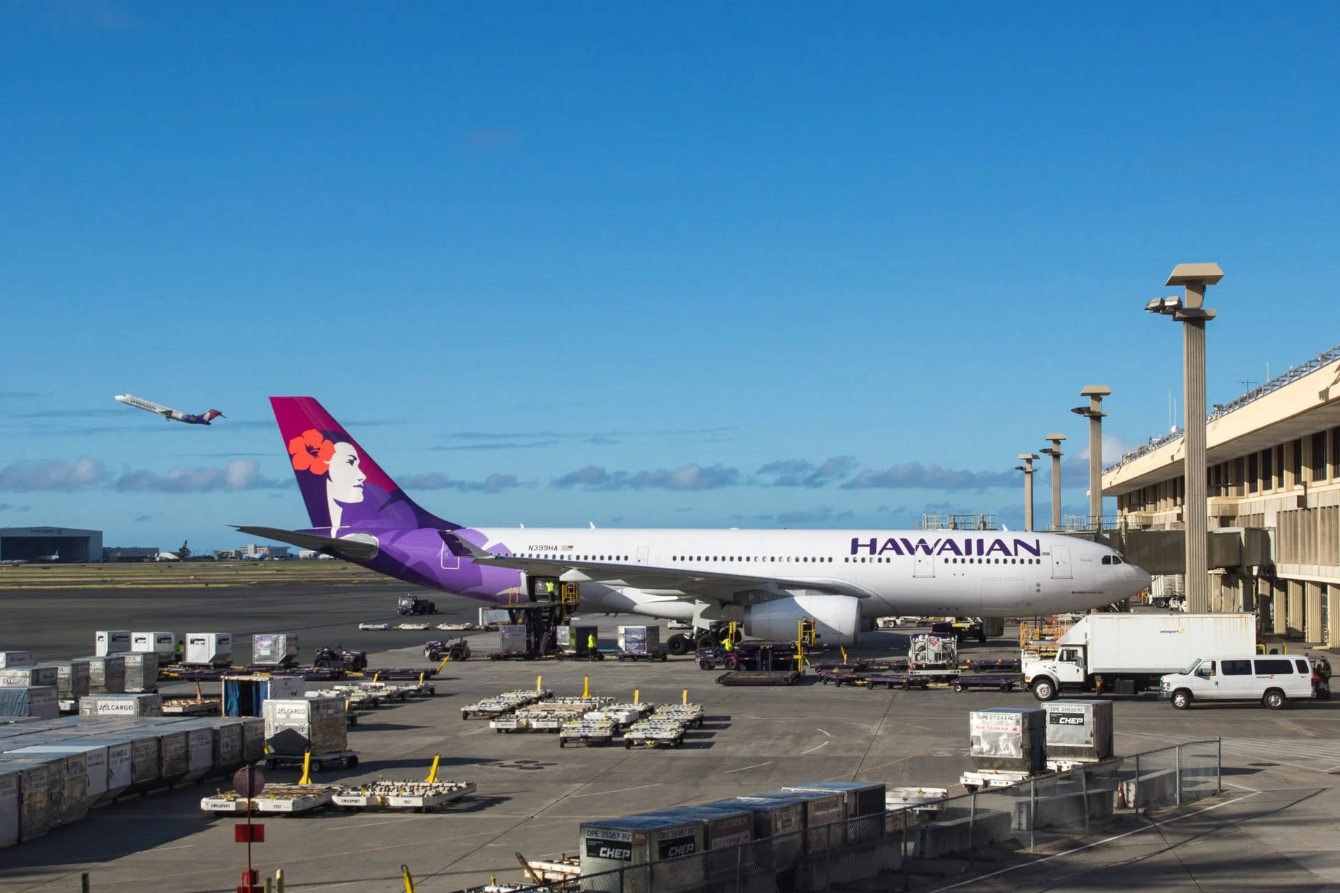 夏威夷航空噴射機停在機場閘口，有貨物，另一架飛機在空中。 — 夏威夷 壁紙