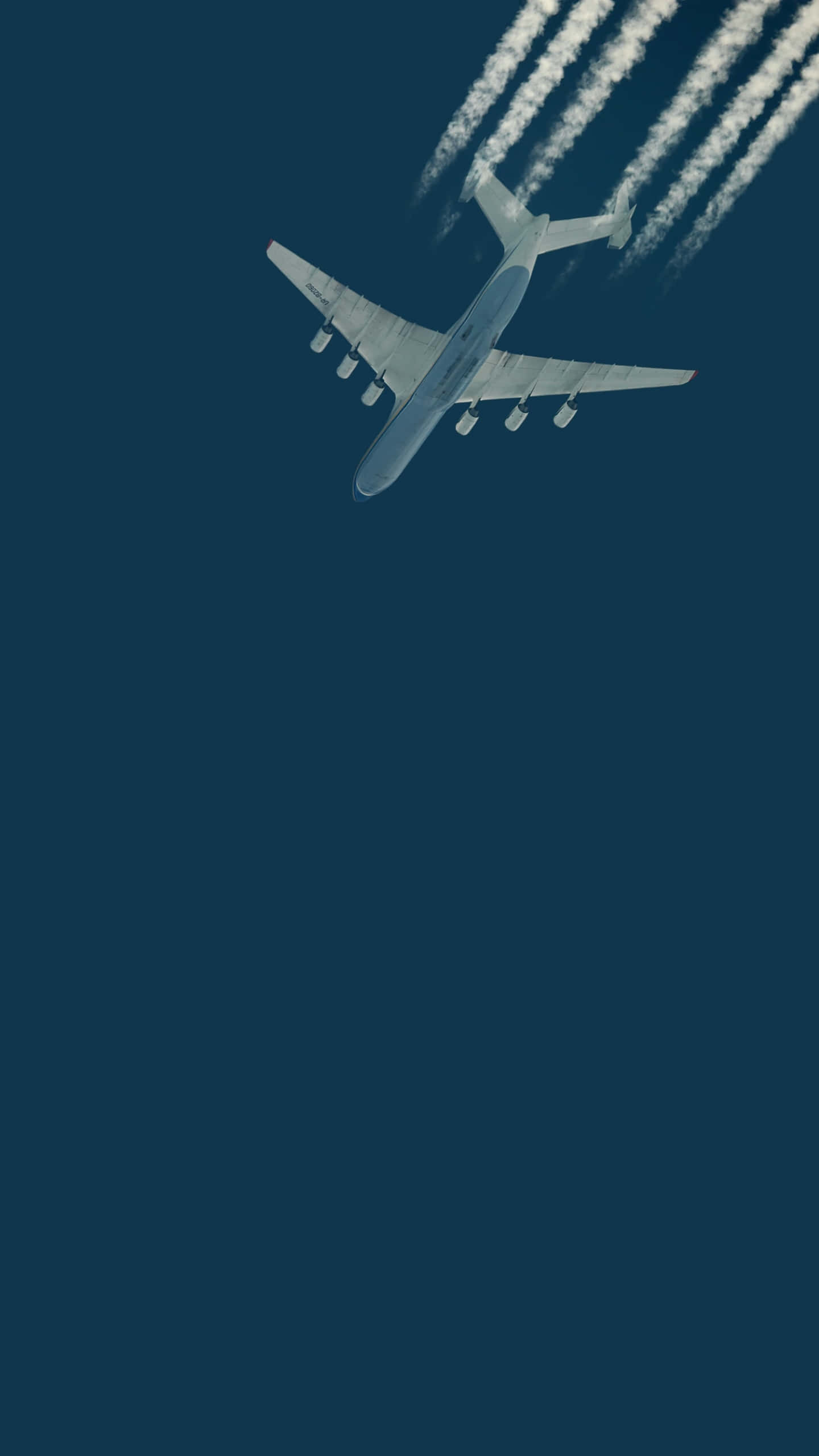 Aerospace 桌布 壁紙 — 一架大型商用飛機在深藍色的天空中翱翔，留下四條清晰的白煙痕跡。