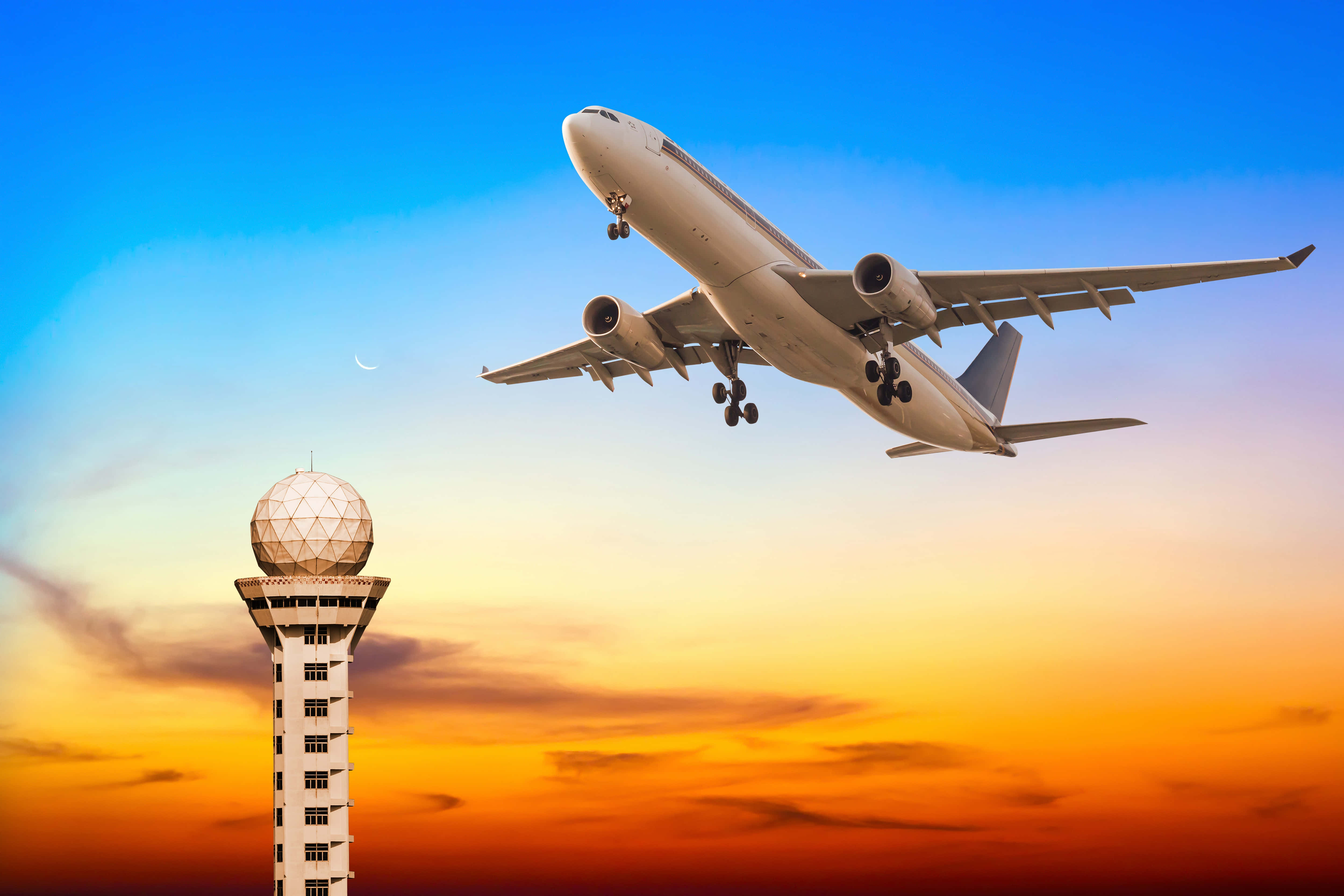 Plane 桌布 壁紙 — 一架大型客機在充滿活力的日落天空和彎月的襯托下，從機場控制塔旁下降。