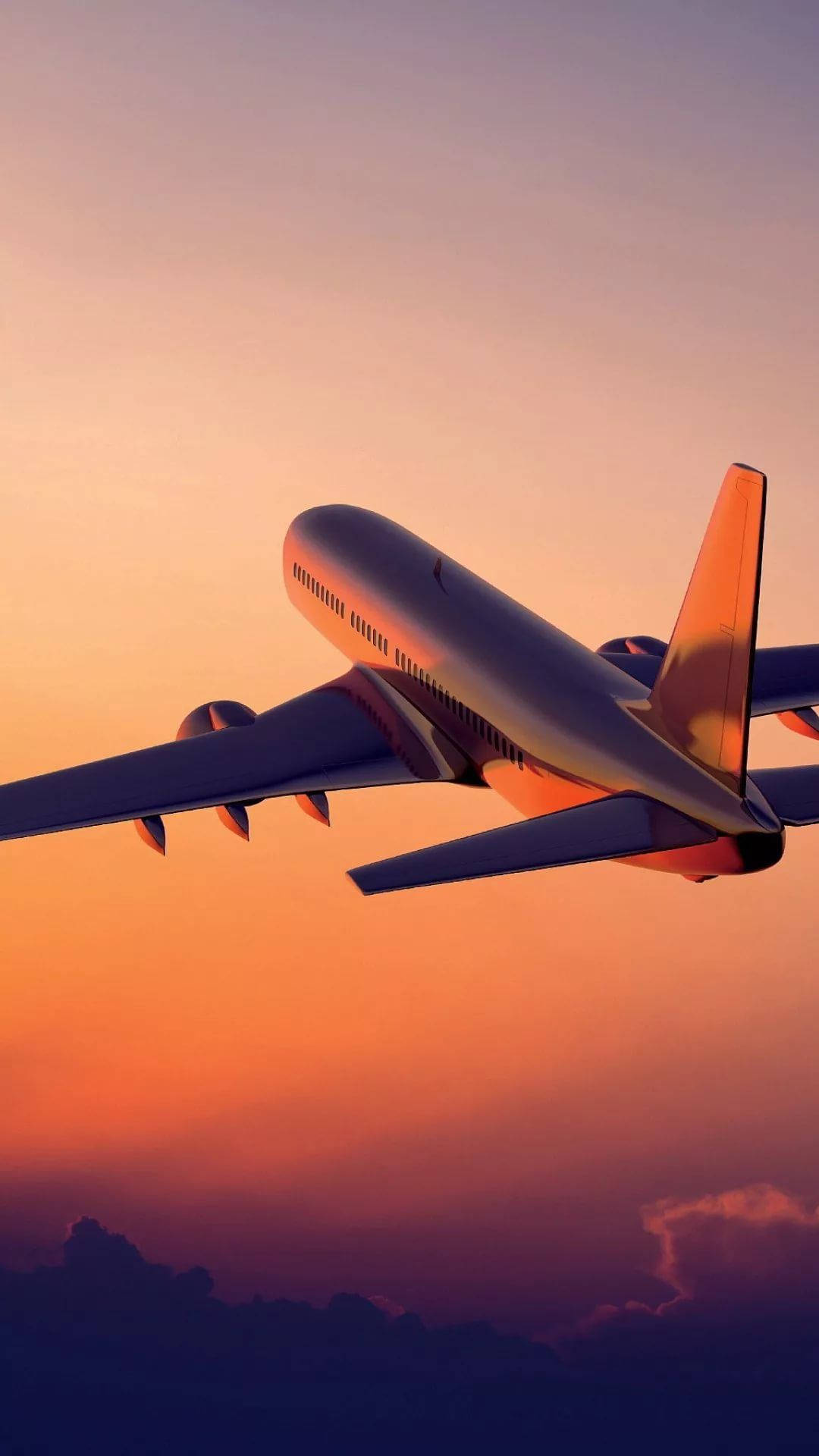 飛機 桌布 壁紙 — 一架大型客機在充滿活力的橙紫色日落天空中翱翔，下方有柔軟的雲層。