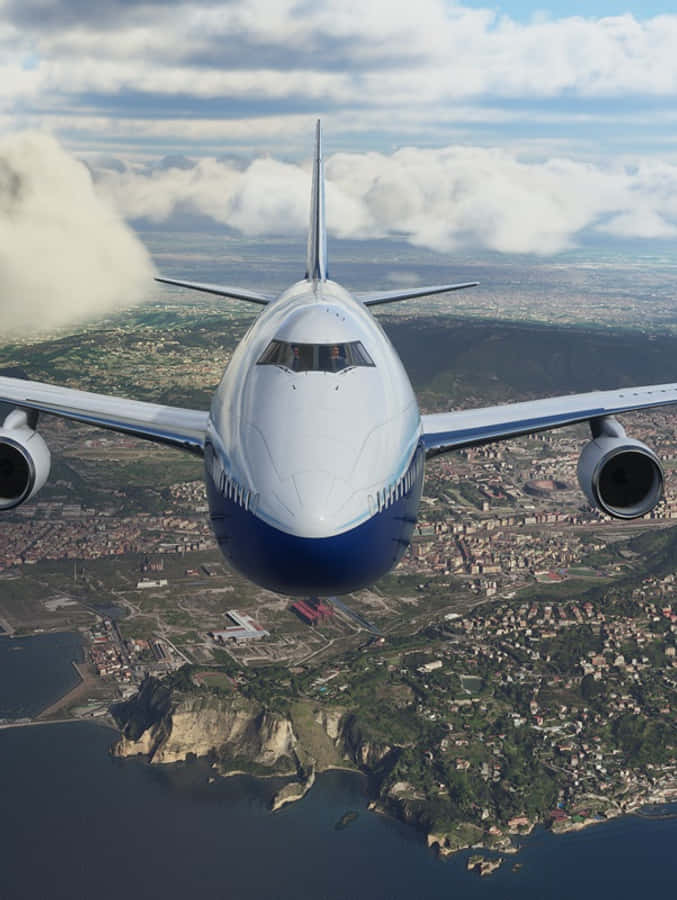 Android Microsoft Flight Simulator 桌布 壁紙 — 一架大型客機飛越一個擁有懸崖和海洋的沿海城市上空，天空部分多雲。