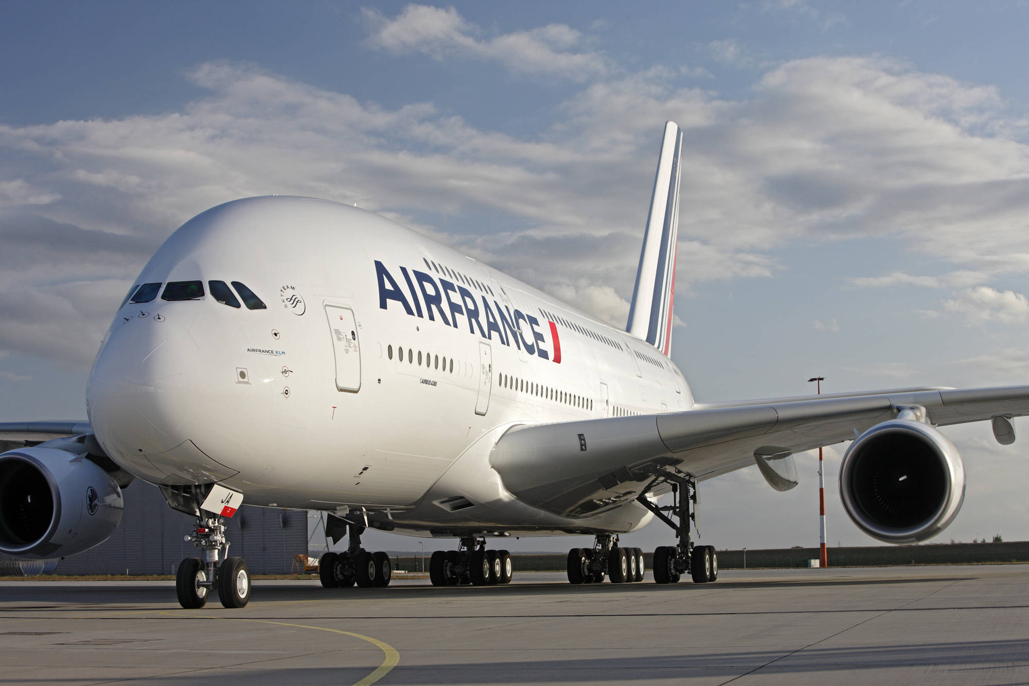 Plane 桌布 壁紙 — 一架大型白色法國航空空中巴士A380停放在機場停機坪上，天空局部多雲。