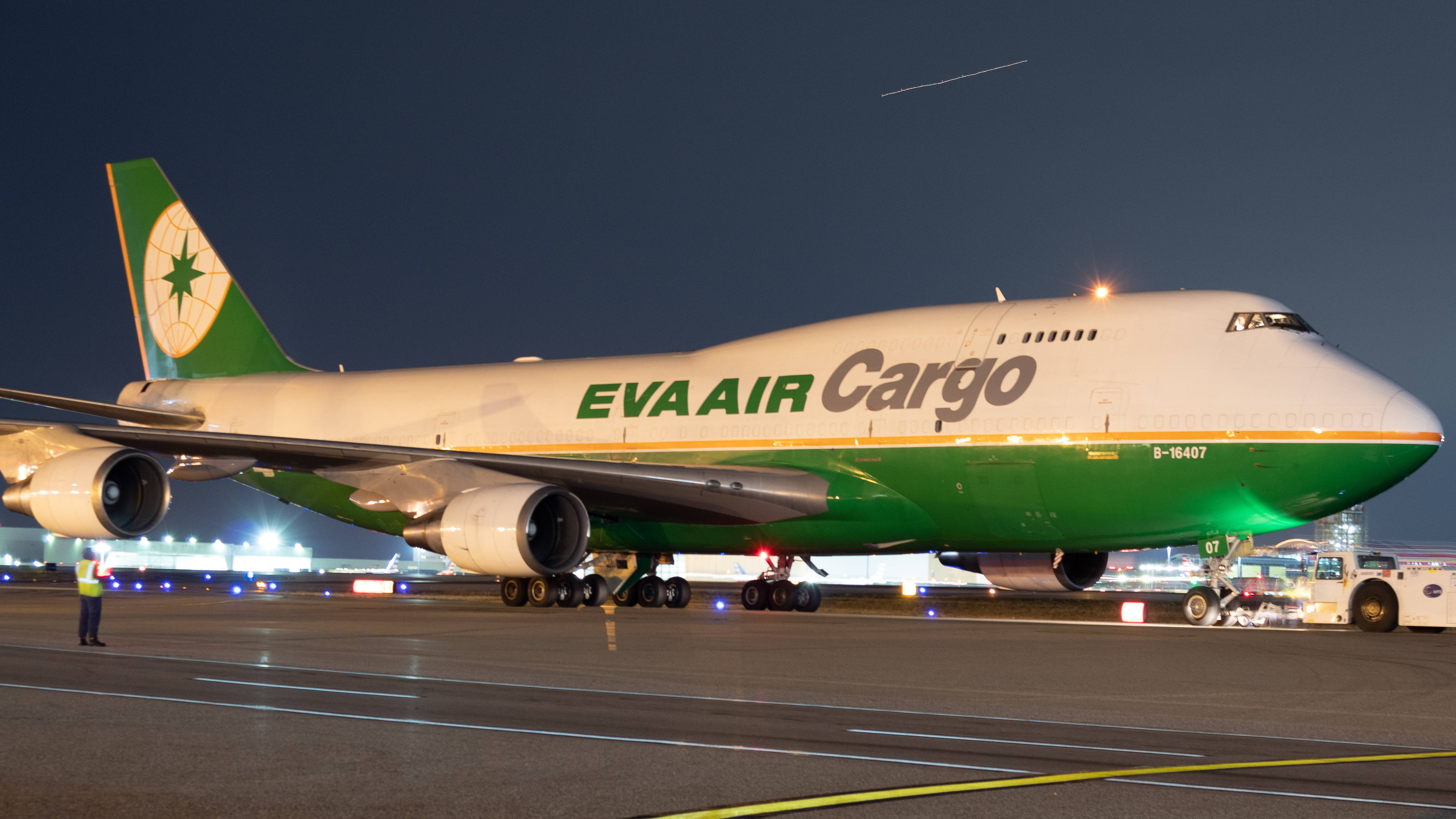 Airport 桌布 壁紙 — 一架大型綠色和白色的EVA Air Cargo波音747在夜間停機坪上被照亮，地勤人員在附近。