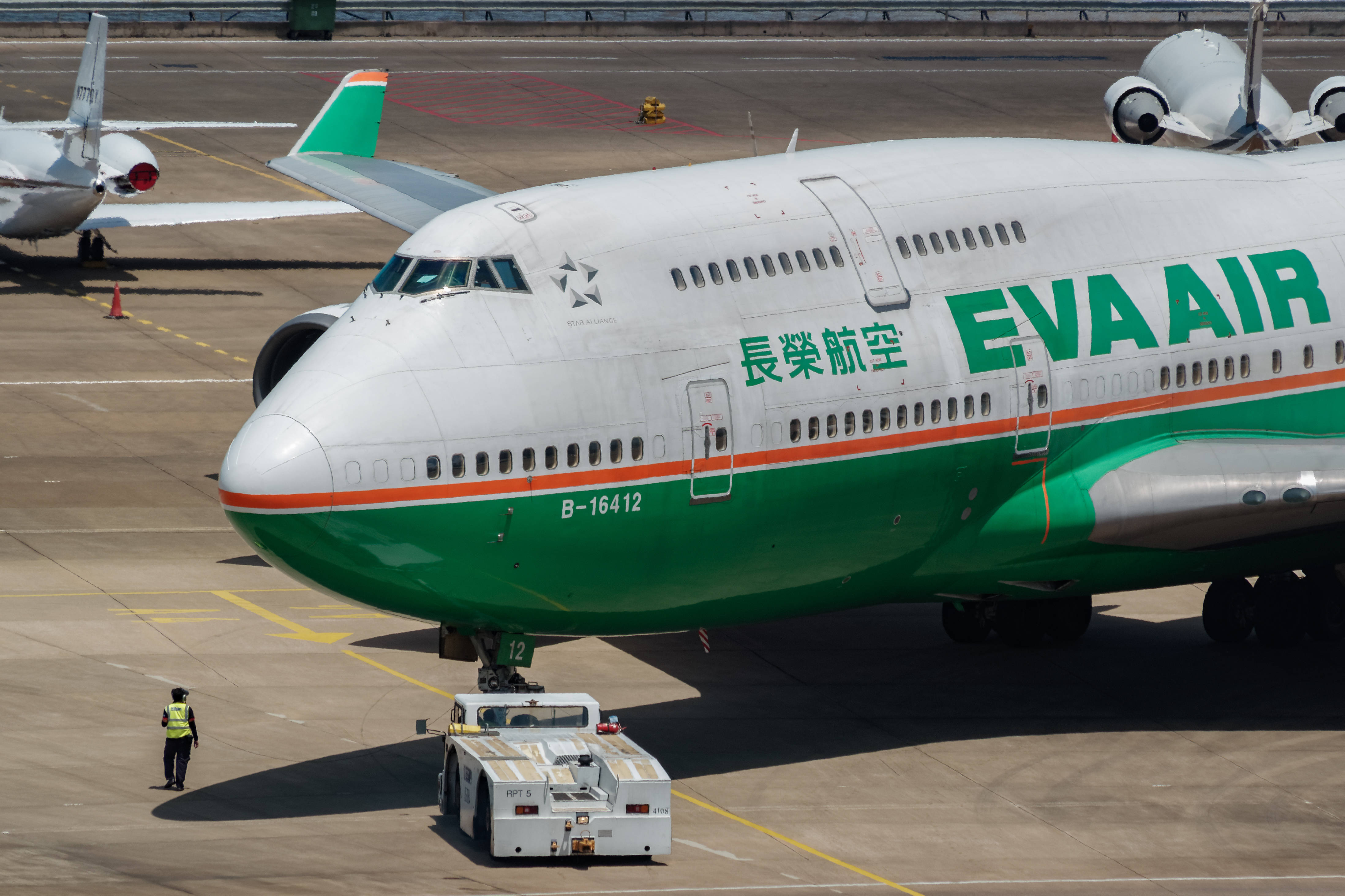 Airport 桌布 壁紙 — 一架大型長榮航空波音747停泊在陽光明媚的停機坪上，附近有地勤人員和牽引車。
