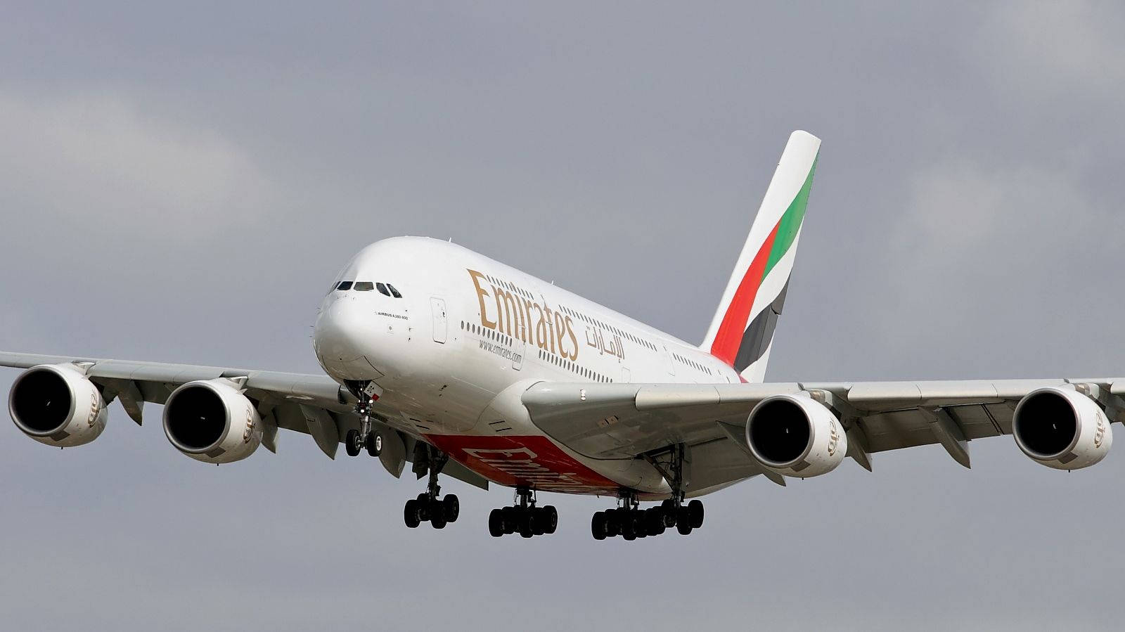 飛機 桌布 壁紙 — 一架大型阿聯酋航空空中巴士A380飛機在陰天中放下起落架下降。