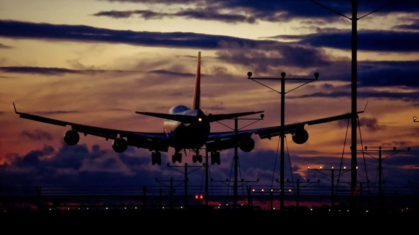 Plane 桌布 壁紙 — 一架大型飛機在橙紫色雲彩的戲劇性暮色天空中呈現剪影。