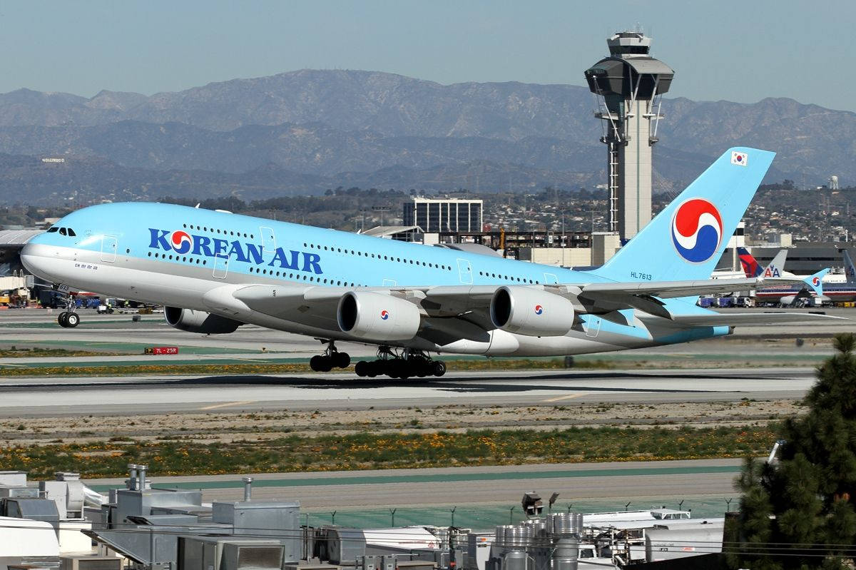 Airport 桌布 壁紙 — 一架大韓航空空中巴士A380在晴朗天空下滑行在跑道上，背景有山脈和機場控制塔。