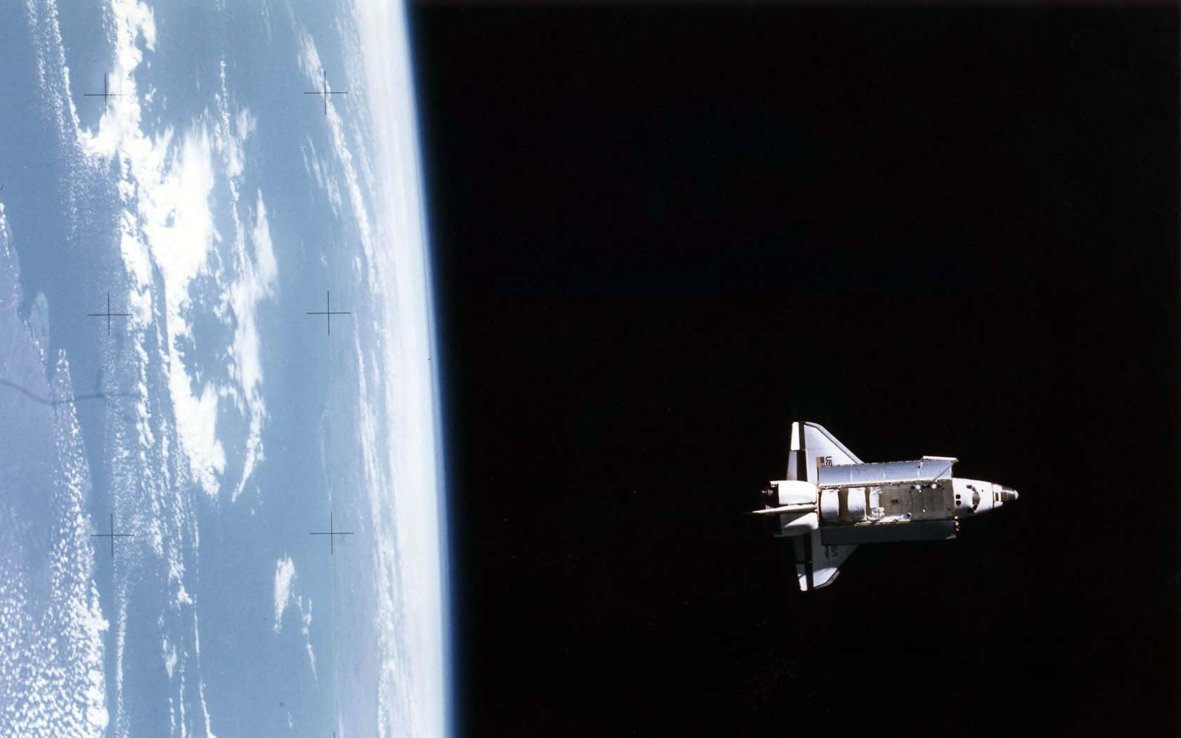 space shuttle 桌布 壁紙 — 一架太空梭滑過地球彎曲的地平線，展示藍色海洋、白色雲朵和其後的黑色虛空。