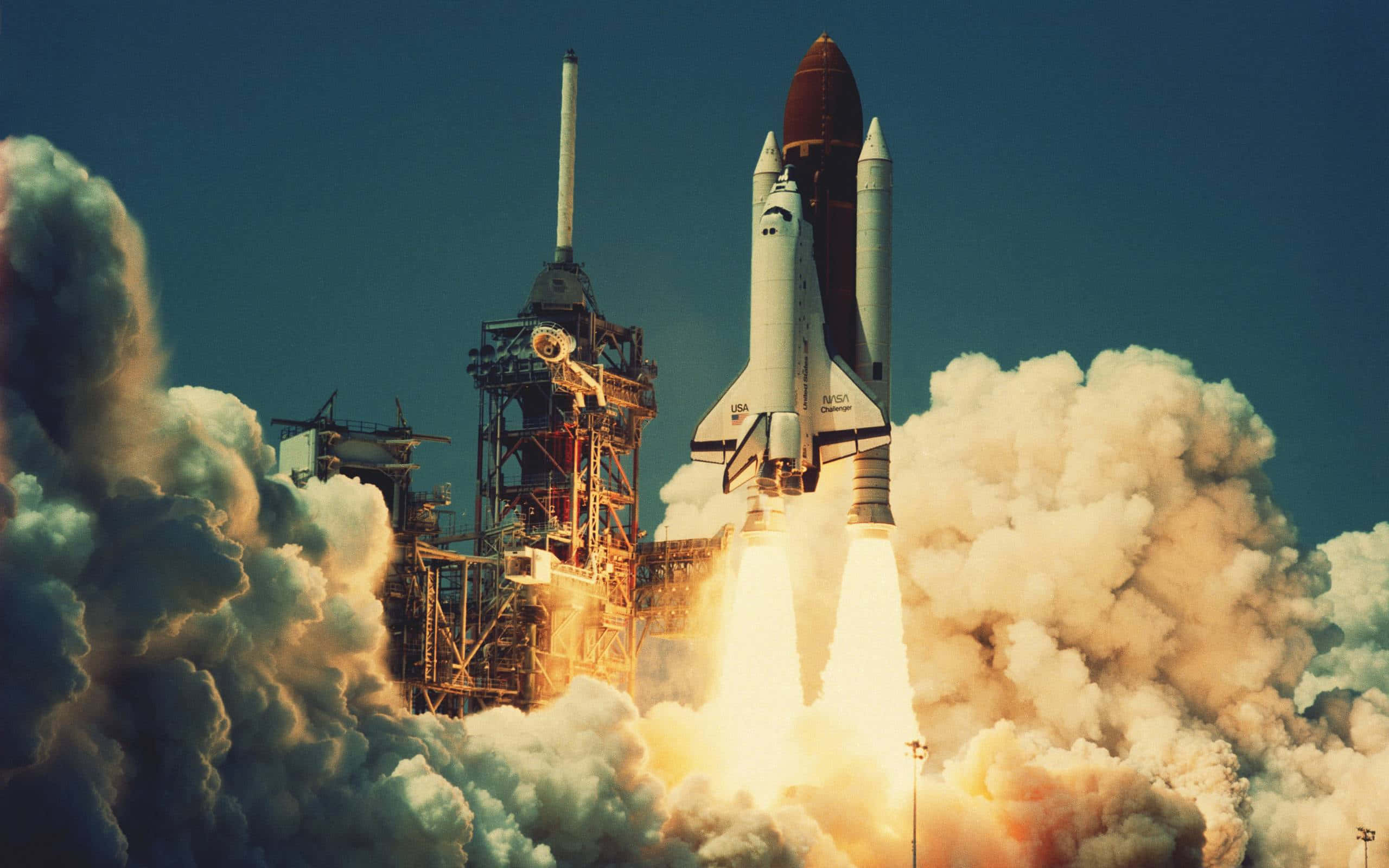 space shuttle 桌布 壁紙 — 一架太空梭點燃引擎，從被滾滾濃煙和火焰吞沒的發射台升空。
