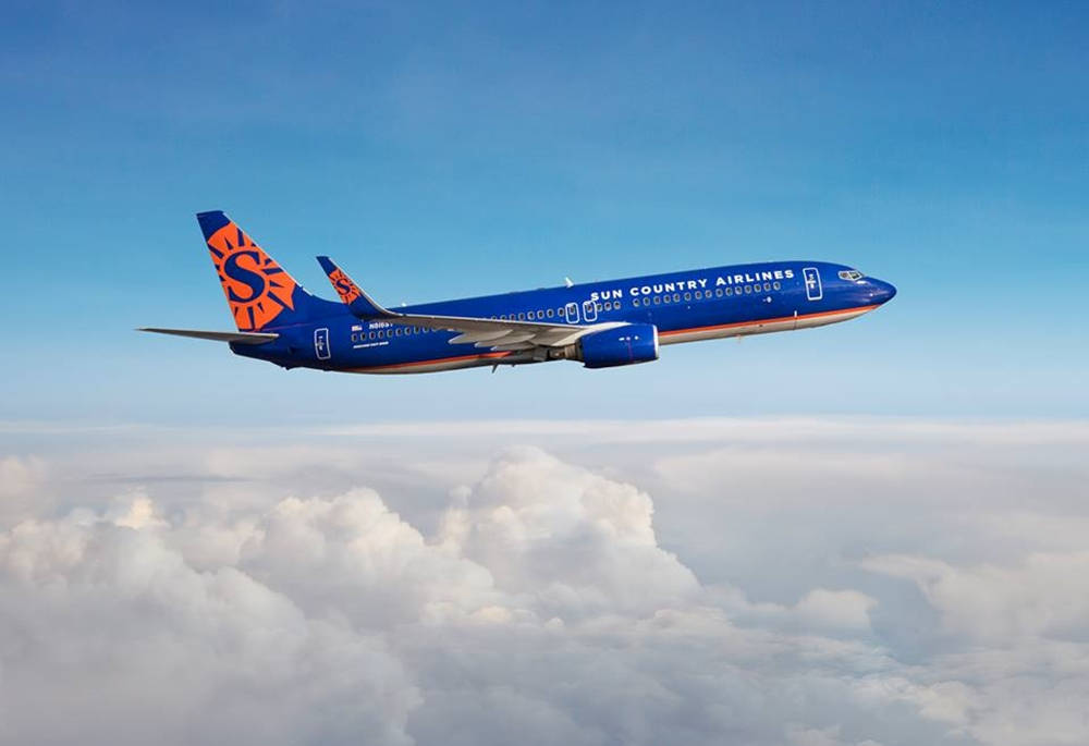 飛機 桌布 壁紙 — 一架太陽鄉村航空公司的噴射機在晴朗的藍天下翱翔於蓬鬆的白雲之上。