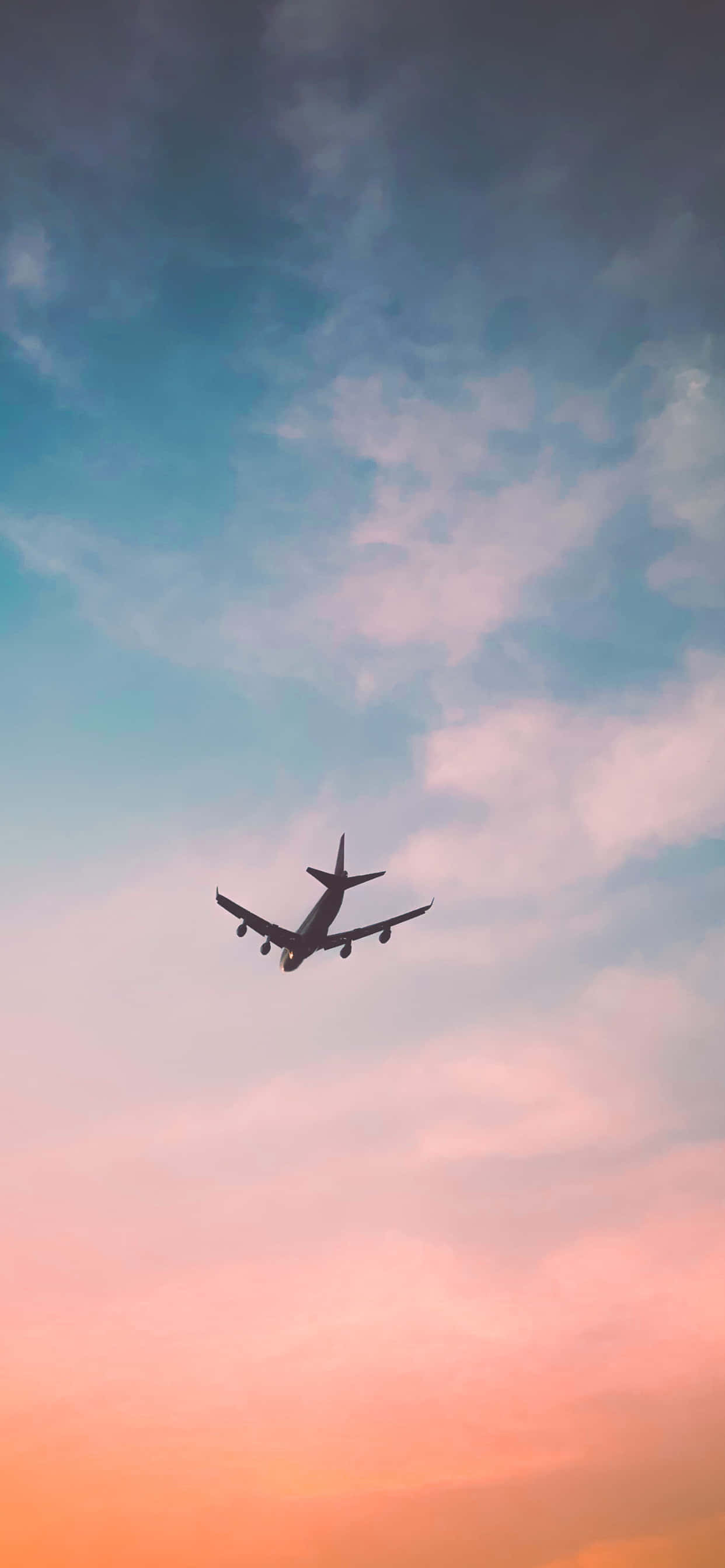 iPhone Xs Max Small Planes 桌布 壁紙 — 一架孤獨的飛機在由柔和粉紅、橙色和藍色雲彩繪成的 vibrant 暮色天空中呈現剪影。