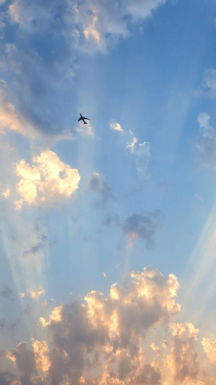 飛機 桌布 壁紙 — 一架孤獨的飛機翱翔在由金色雲彩和燦爛陽光繪成的鮮豔天空中。