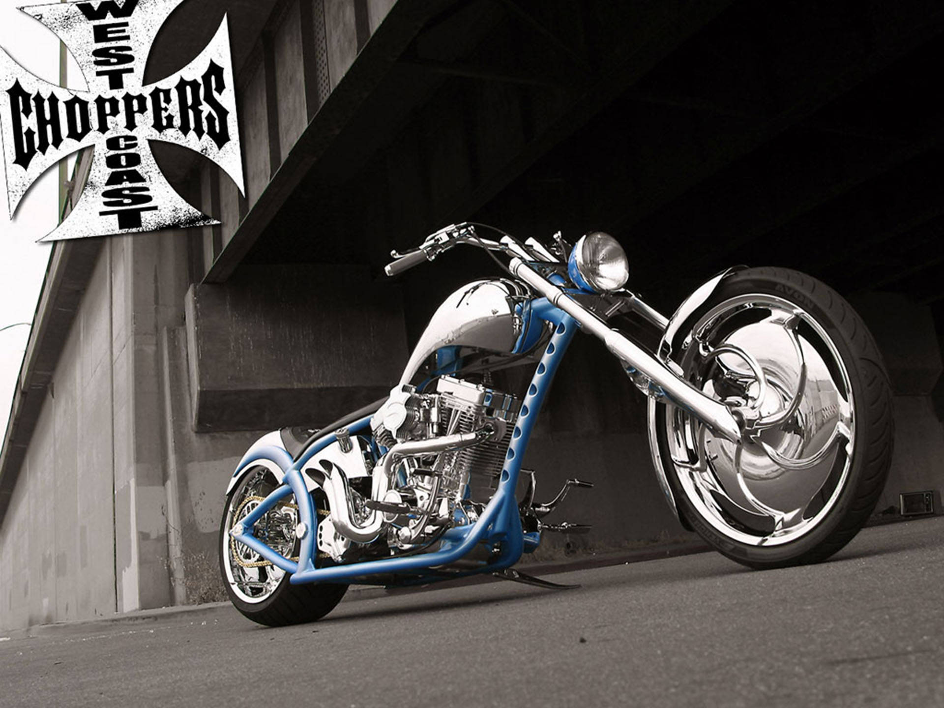 Choppers 桌布 壁紙 — 一架定製的藍色和鍍鉻chopper摩托車停放在混凝土天橋下，帶有'West Coast Choppers'標誌。