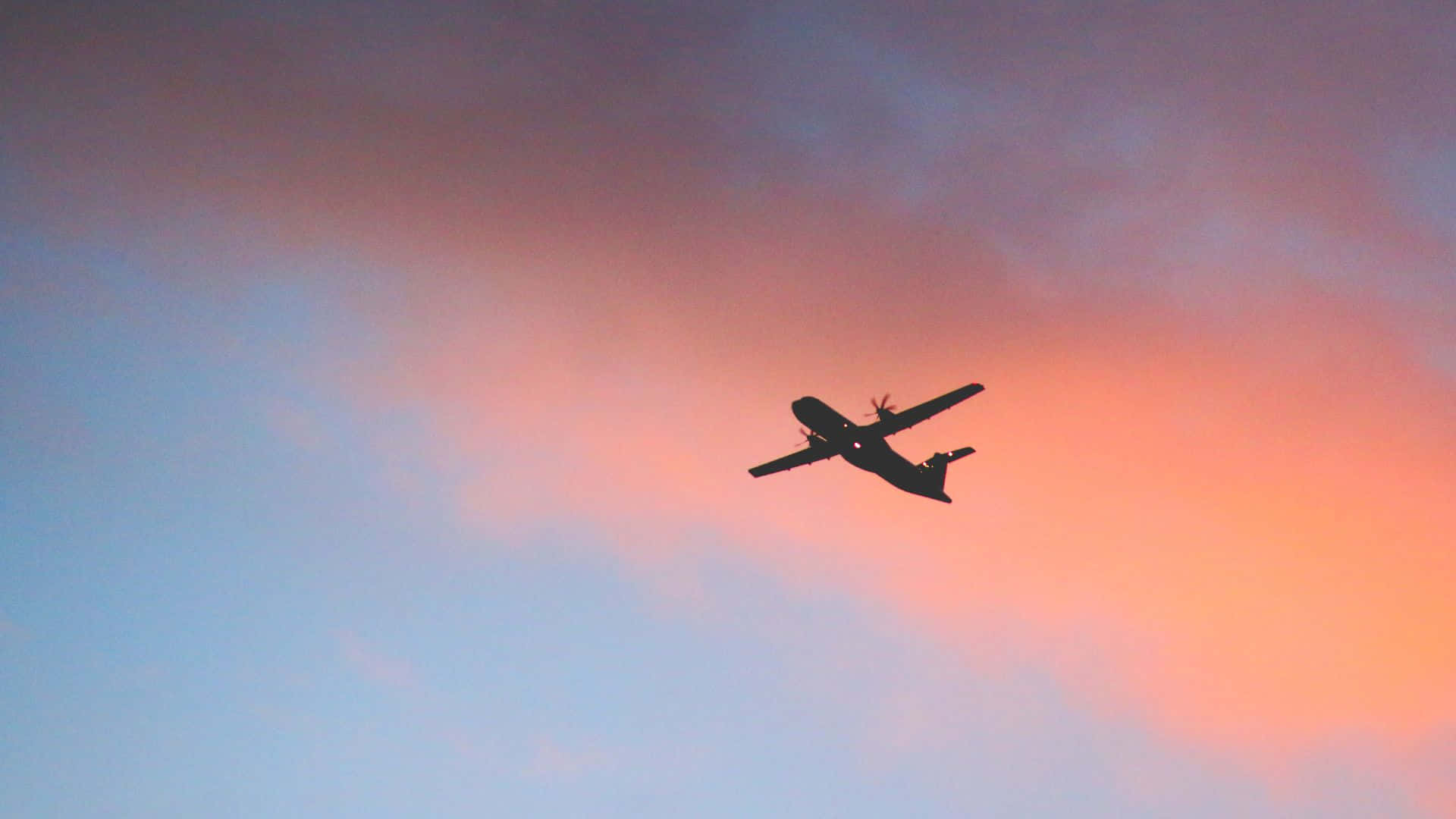 飛機剪影飛過色彩繽紛的日落天空。 — 飛機 壁紙