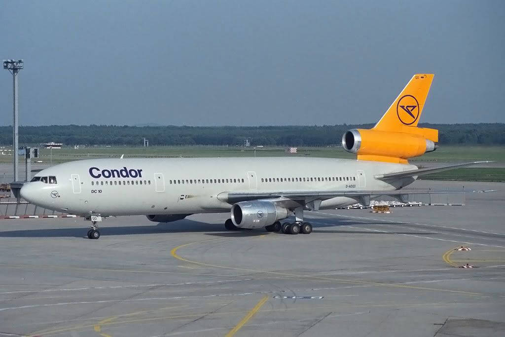 Airport 桌布 壁紙 — 一架尾翼鮮橙色的Condor DC-10客機，在晴朗天空下停在機場停機坪上。