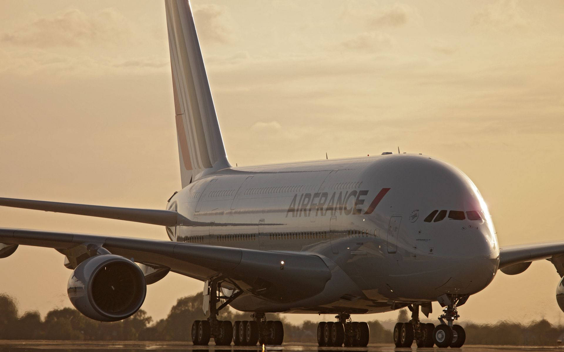Plane 桌布 壁紙 — 一架巨大的法國航空空中巴士A380停在沐浴在金色日落光線下的跑道上，上方有柔軟的雲朵。