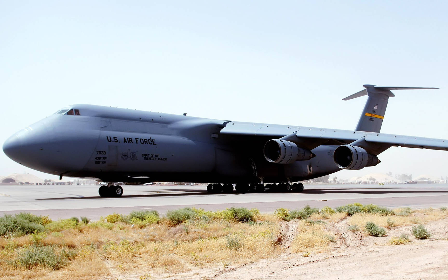 Iraq 桌布 壁紙 — 一架巨大的灰色美國空軍C-5銀河貨機停在沙漠跑道上，天空清澈湛藍。