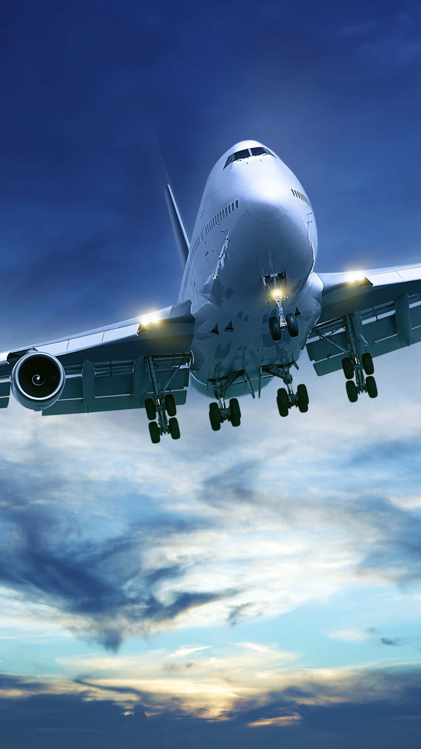 Plane 桌布 壁紙 — 一架巨大的白色珍寶客機正在下降，起落架已放下，背景是佈滿雲彩的戲劇性暮色天空。