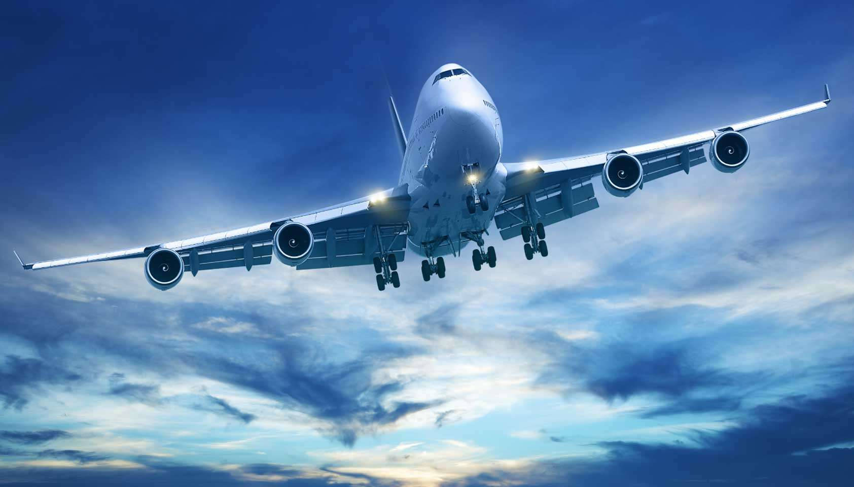 飛機 桌布 壁紙 — 一架巨大的白色珍寶客機正放下起落架，在雲彩斑斕的戲劇性藍天下向地球下降。