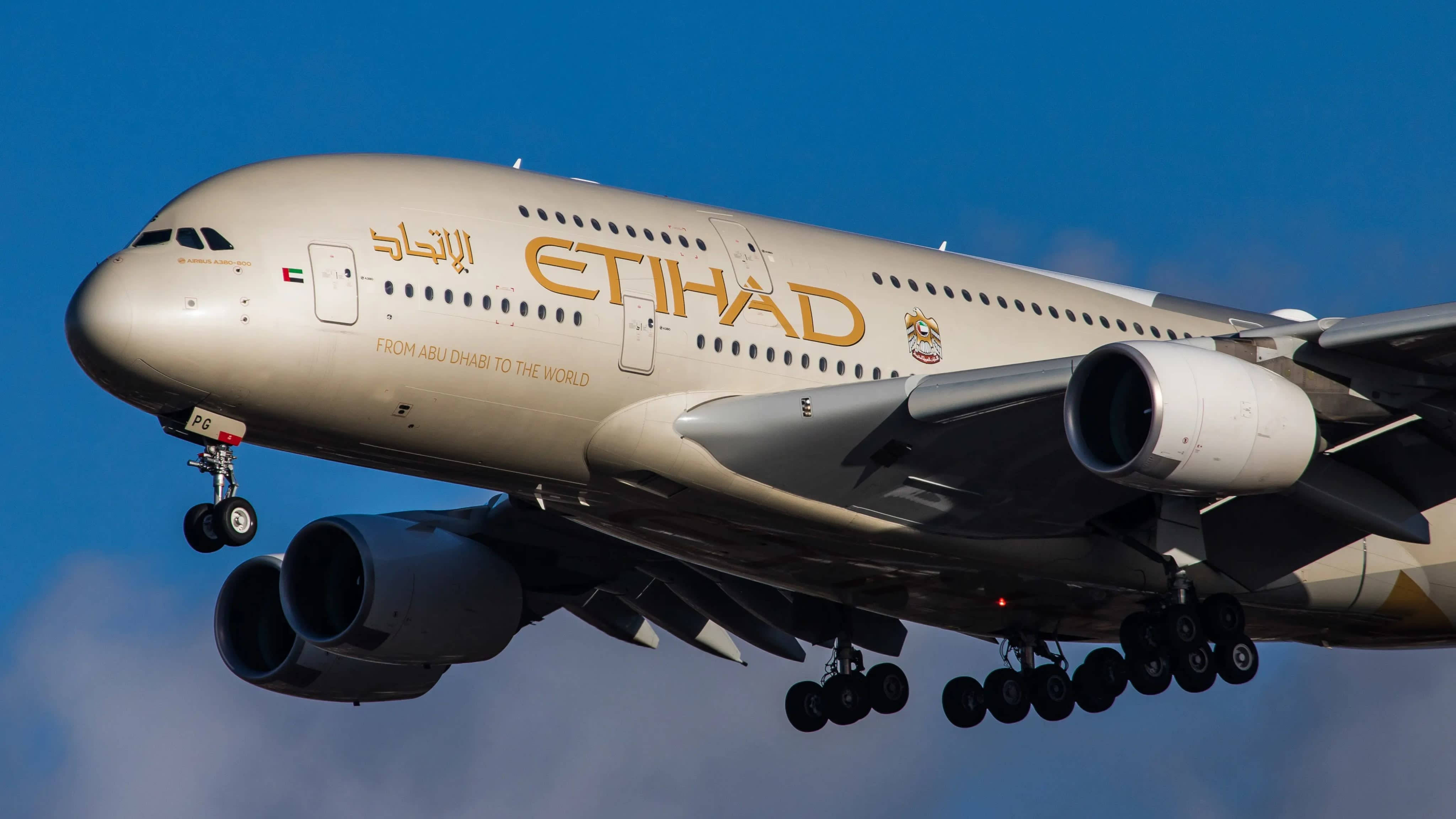 Blue Sky 桌布 壁紙 — 一架巨大的阿提哈德航空空中巴士A380飛機在晴朗的藍天下放下起落架下降。
