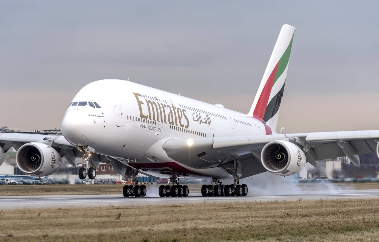 Airport 桌布 壁紙 — 一架巨大的阿聯酋航空空中巴士A380在多雲的天空下滑行在跑道上，起落架放下，引擎轟鳴。