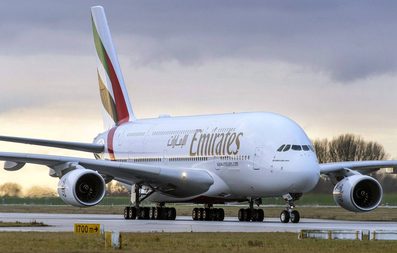 飛機 桌布 壁紙 — 一架巨大的阿聯酋航空空中巴士A380在陰天和黃金時段的光線下滑行在跑道上。