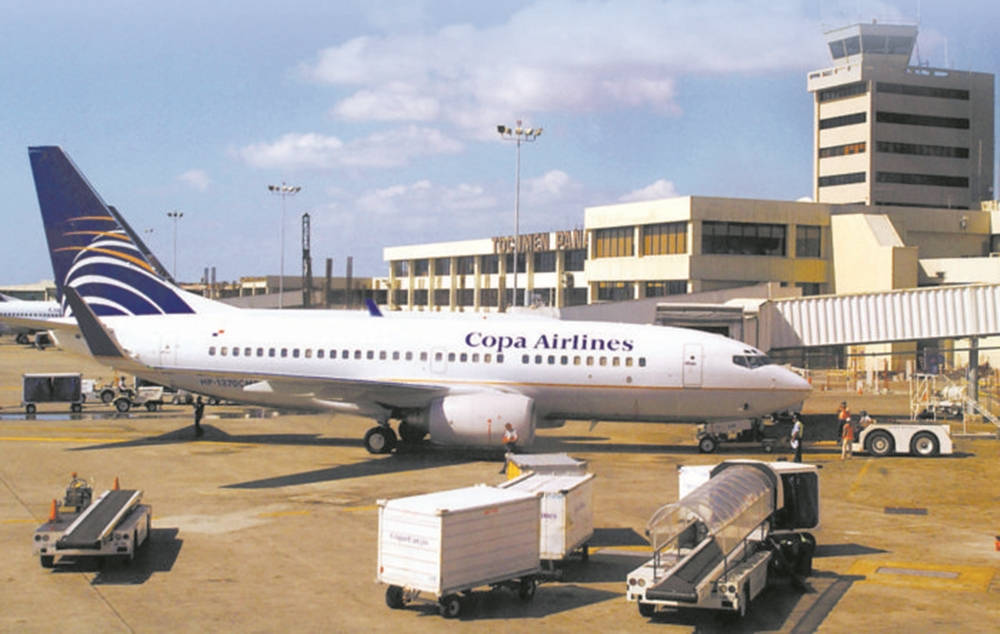 Airport 桌布 壁紙 — 一架巴拿馬航空飛機停泊在陽光明媚的機場登機門，附近有地勤人員和行李車。