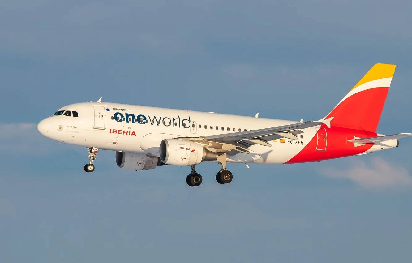 Blue Sky 桌布 壁紙 — 一架帶有 one world 塗裝的伊比利亞航空空巴 A320 正在展開起落架，在柔和藍天下下降。