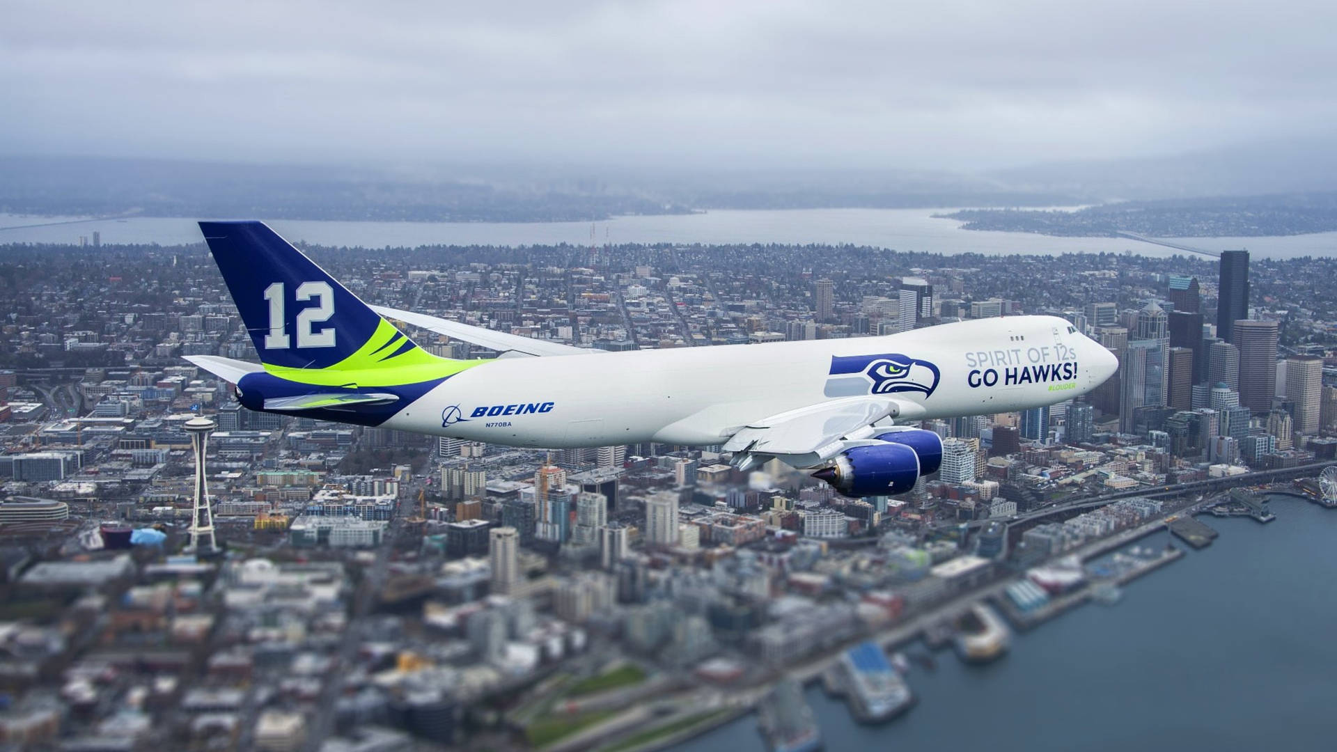 帶有Seahawks品牌的波音747飛越西雅圖城市景觀。