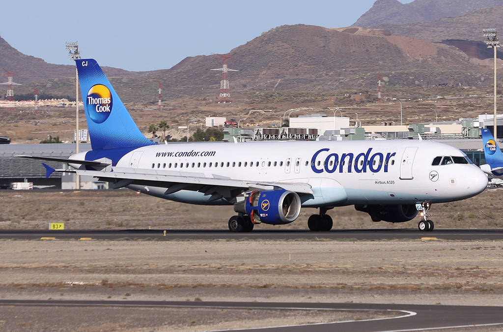 Airport 桌布 壁紙 — 一架帶有Thomas Cook塗裝的Condor Airbus A320在乾燥山丘和清澈藍天的背景下在跑道上滑行。