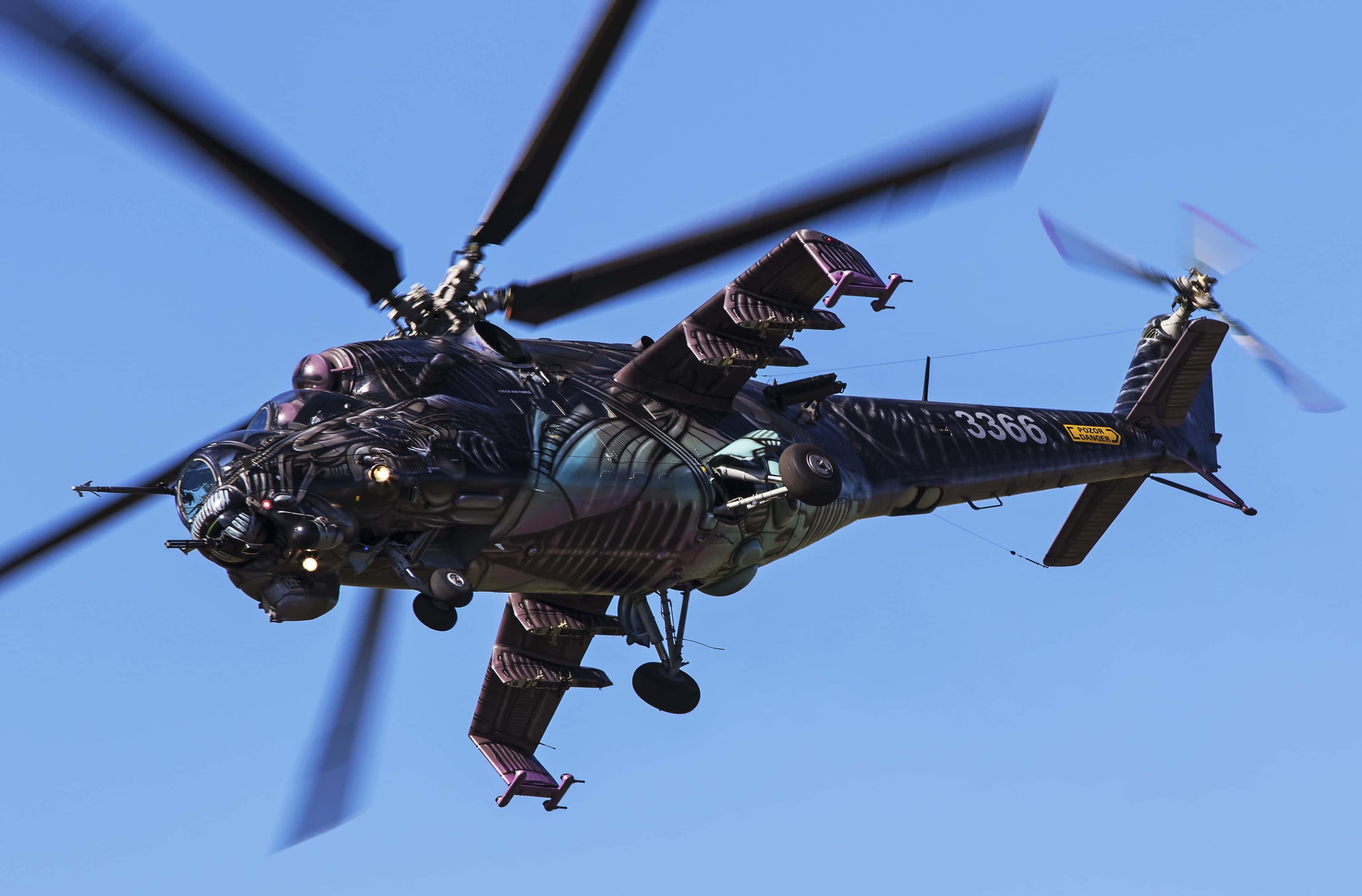 Helicopters 桌布 壁紙 — 一架帶有外星主題迷彩的軍用直升機在晴朗的藍天下旋轉葉片翱翔。