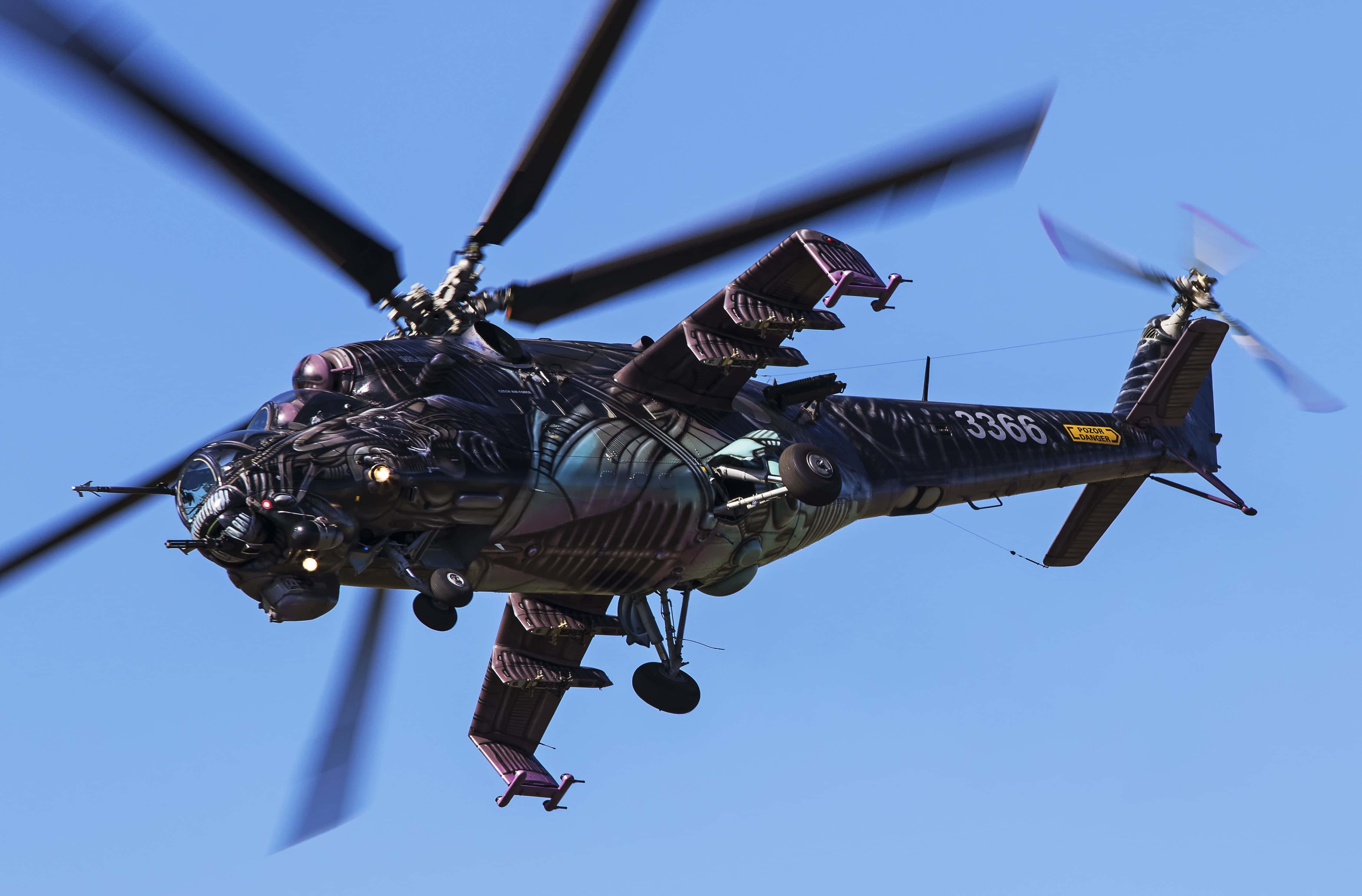 Helicopter 桌布 壁紙 — 一架帶有外星主題迷彩的軍用直升機在晴朗的藍天中翱翔，旋翼轉動。