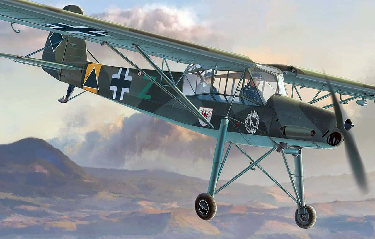 Aircraft 桌布 壁紙 — 一架帶有德國標誌的復古軍用雙翼飛機在多雲的天空下低空飛越山區地形。