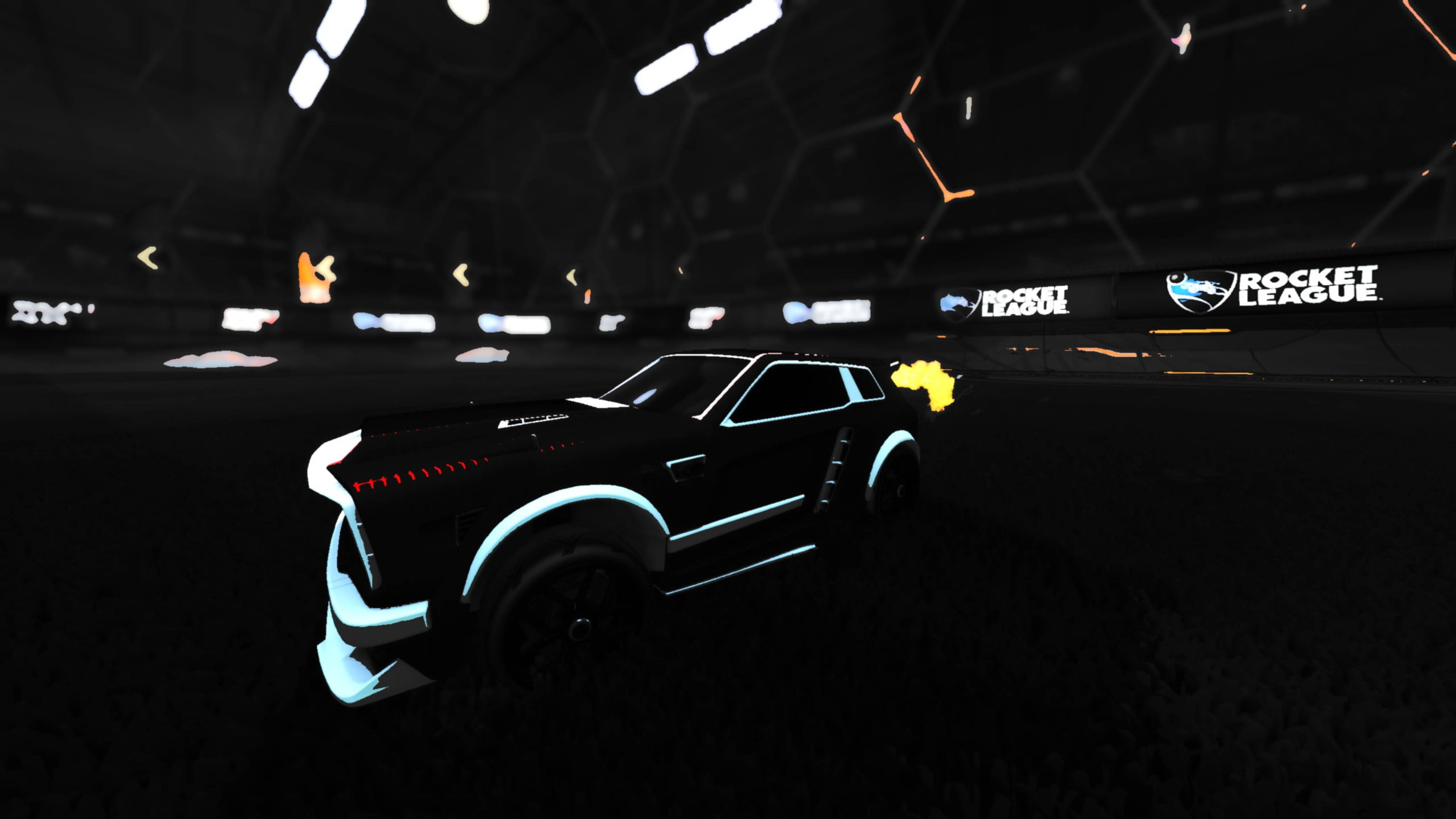 遊戲 桌布 壁紙 — 一架帶有發光藍色飾邊的黑色火箭動力車在《Rocket League》的黑暗競技場中疾馳。