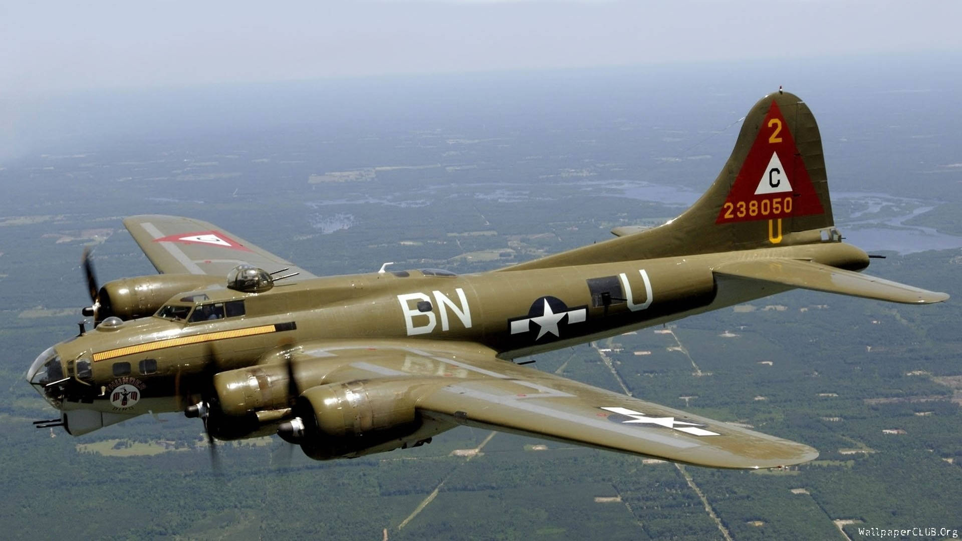 Air Force 桌布 壁紙 — 一架復古橄欖綠色的B-17飛行堡壘轟炸機在朦朧的天空下翱翔於拼布般的景觀之上。