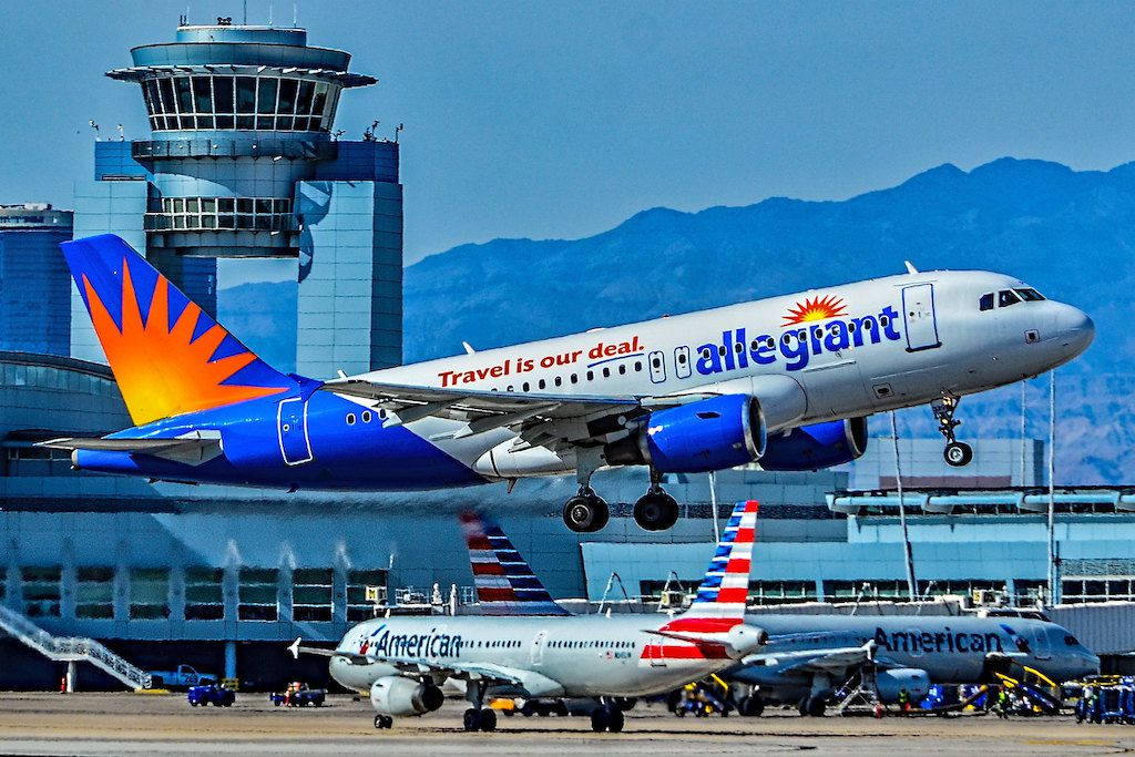 transportation 桌布 壁紙 — 一架忠誠航空公司的飛機在晴朗藍天下，以山脈為背景降落機場。