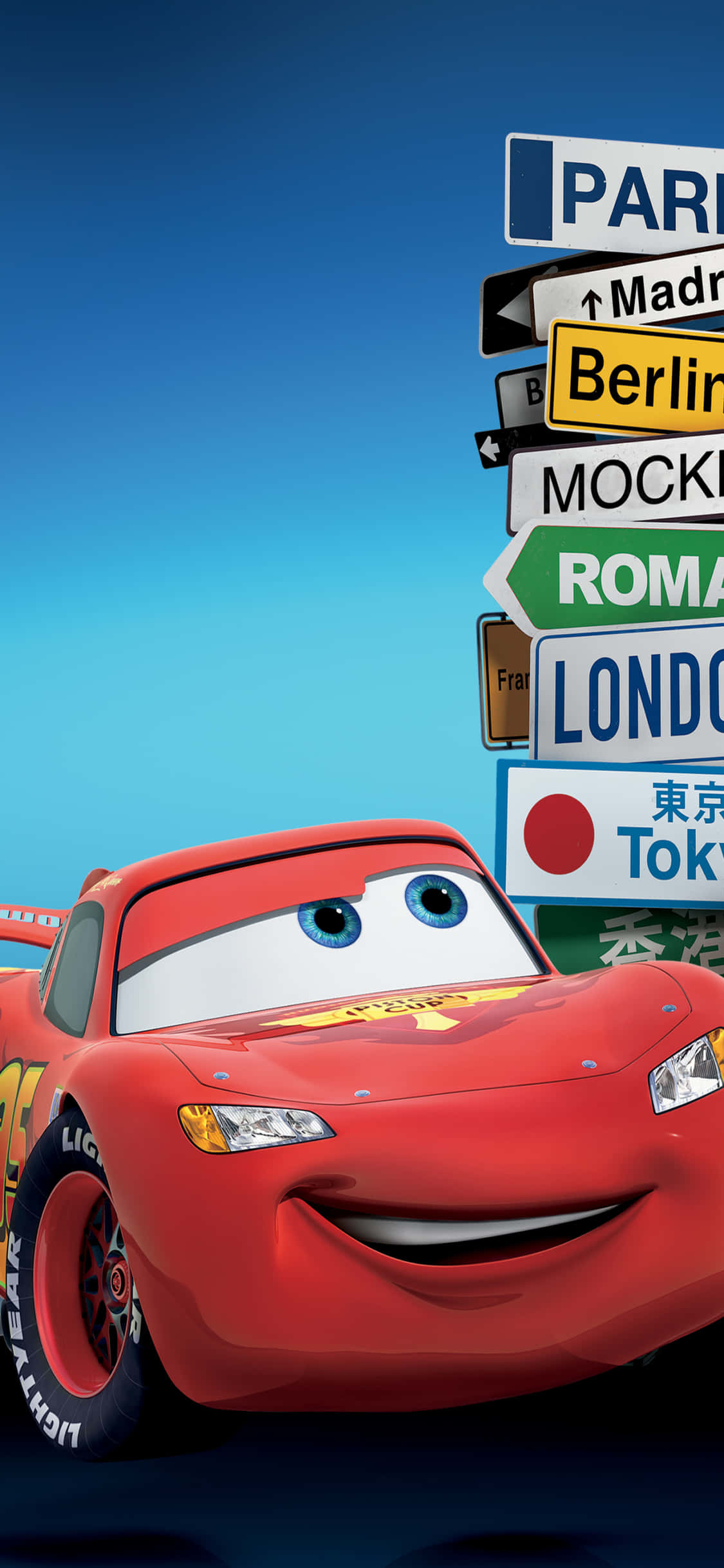Lightning Mcqueen 桌布 壁紙 — 一架快樂的紅色動畫賽車在晴朗的藍天下，在一堆國際城市標誌旁微笑。