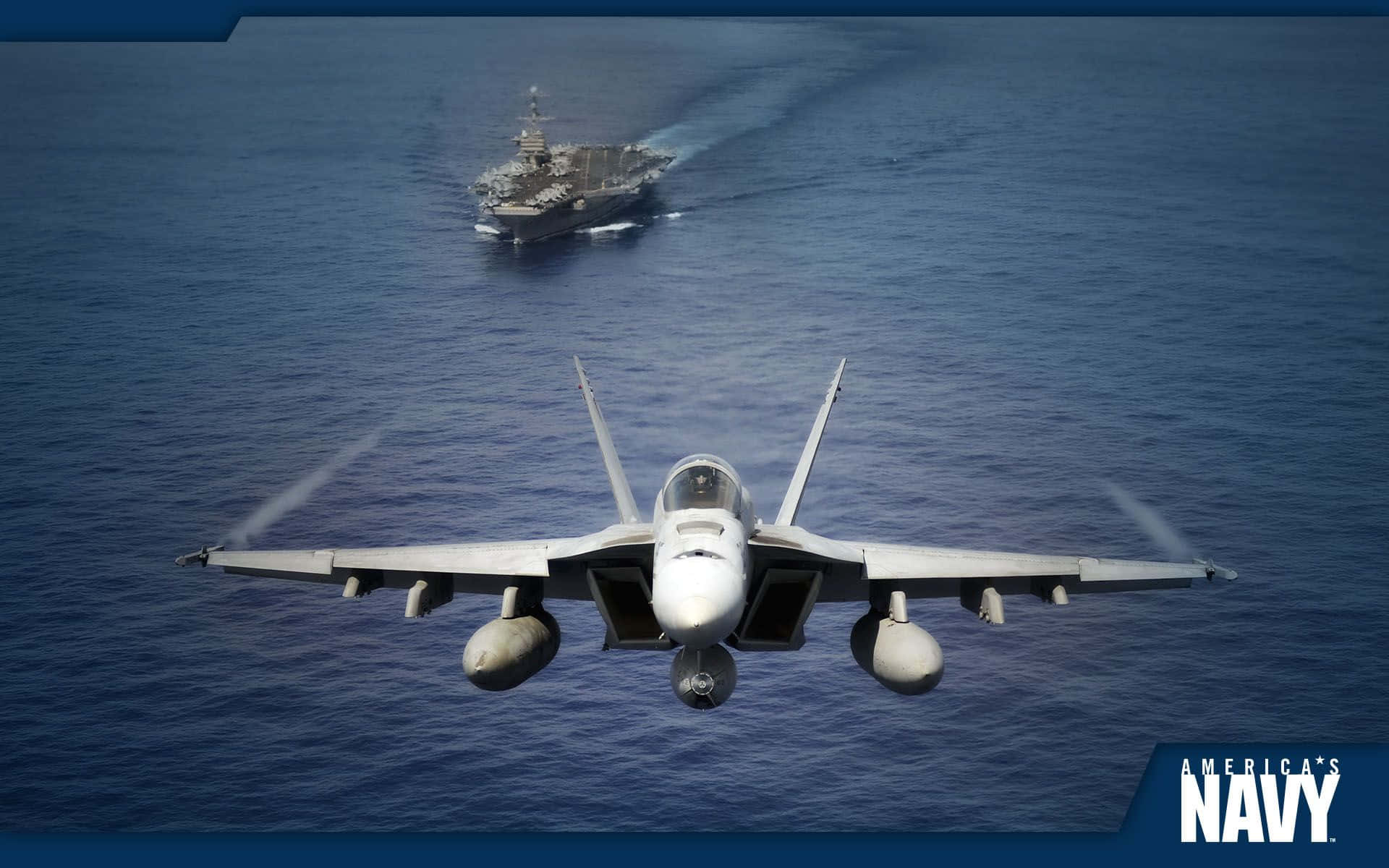 Navy 桌布 壁紙 — 一架戰鬥機在深藍色海洋上空翱翔，遠處可見一艘航空母艦。