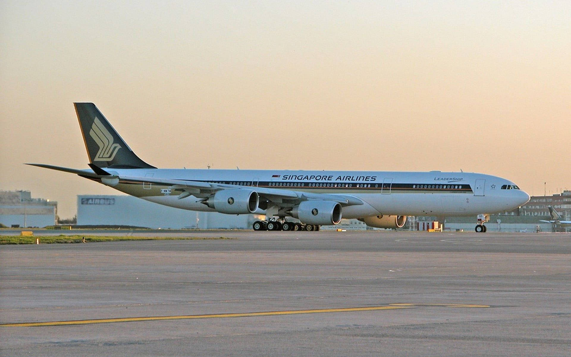Singapore 桌布 壁紙 — 一架新加坡航空的空中巴士A340在溫暖的金色日落時分在機場停機坪上滑行。
