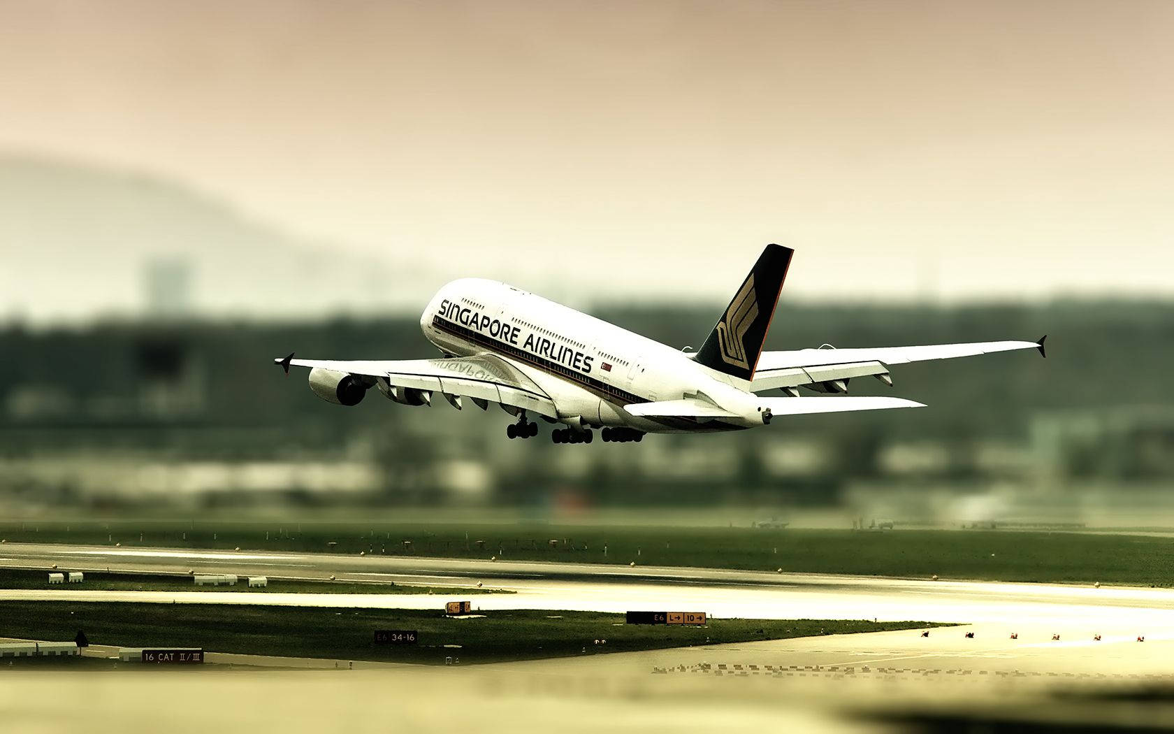 Airport 桌布 壁紙 — 一架新加坡航空的空中巴士A380在朦朧的天空下，從跑道起飛，背景是模糊的機場基礎設施。