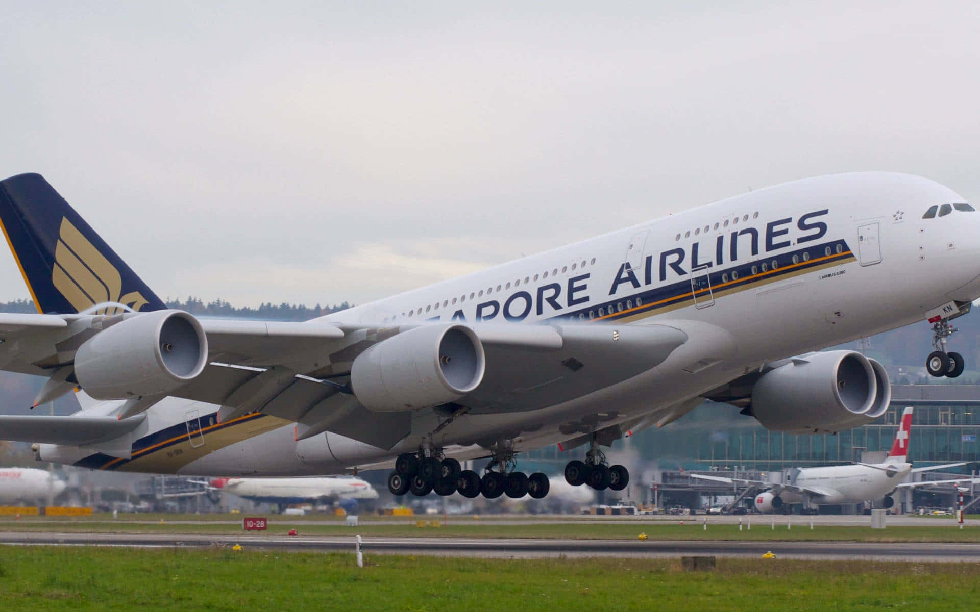 Airport 桌布 壁紙 — 一架新加坡航空空中巴士A380客機放下起落架，在陰天的機場濕滑跑道上滑行。