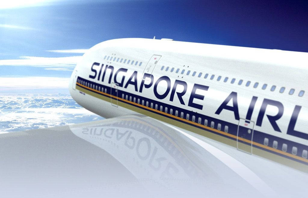 Singapore 桌布 壁紙 — 一架新加坡航空飛機在晴朗藍天下翱翔於蓬鬆白雲之上，陽光在機身上閃爍。