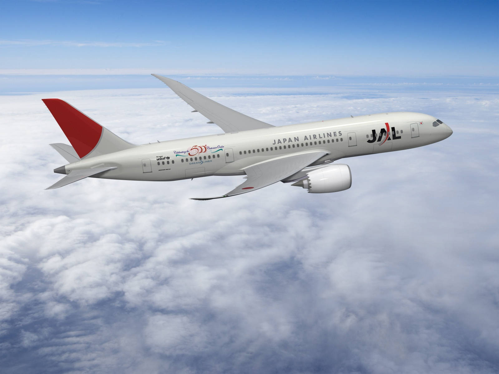 雲朵 桌布 壁紙 — 一架日本航空客機在晴朗藍天下翱翔於蓬鬆白雲之上。