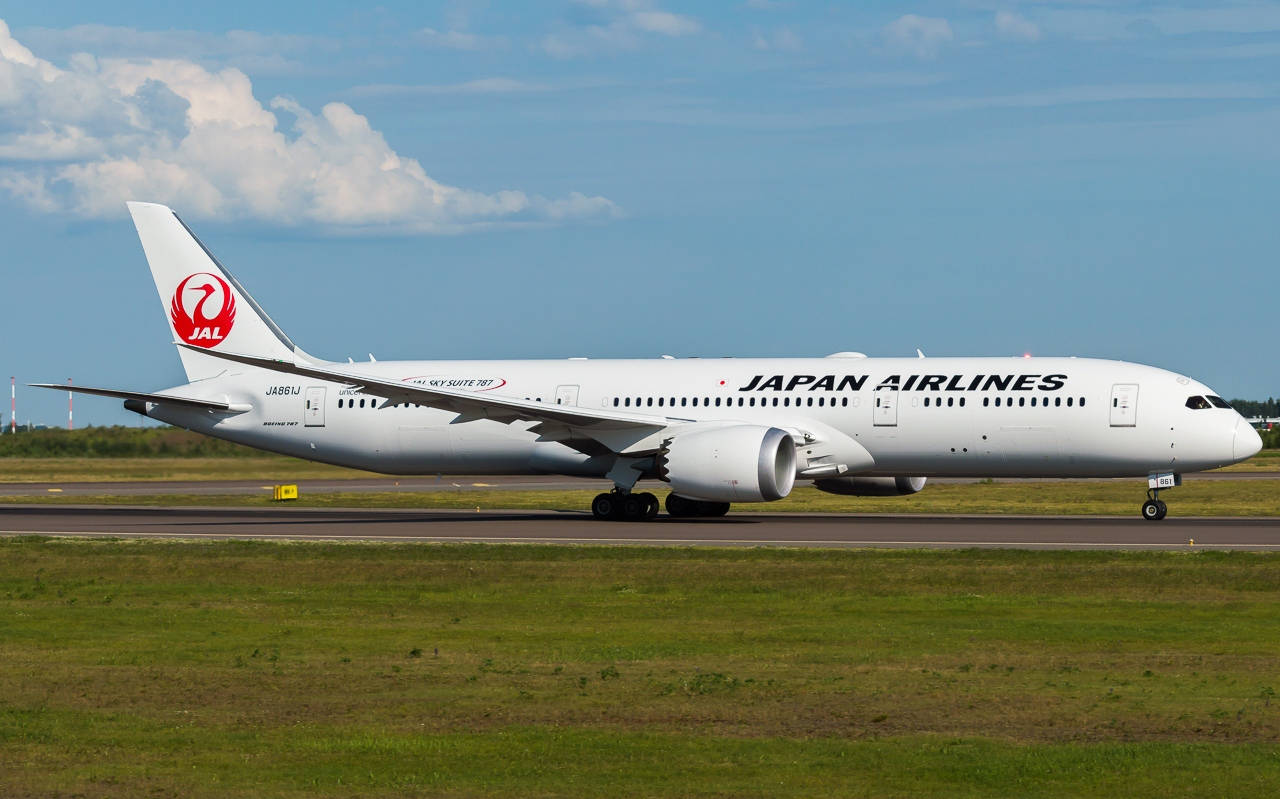 飛機 桌布 壁紙 — 一架日本航空的波音787夢幻客機在晴朗藍天和蓬鬆白雲下滑行在跑道上。