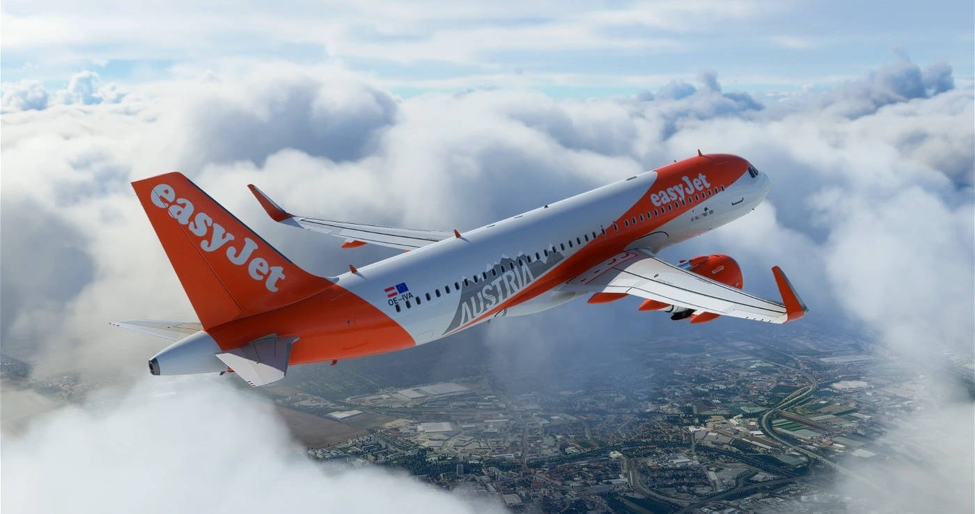 Easyjet 桌布 壁紙 — 一架易捷航空飛機在蓬鬆的白雲上方翱翔，下方可見廣闊的城市景觀。