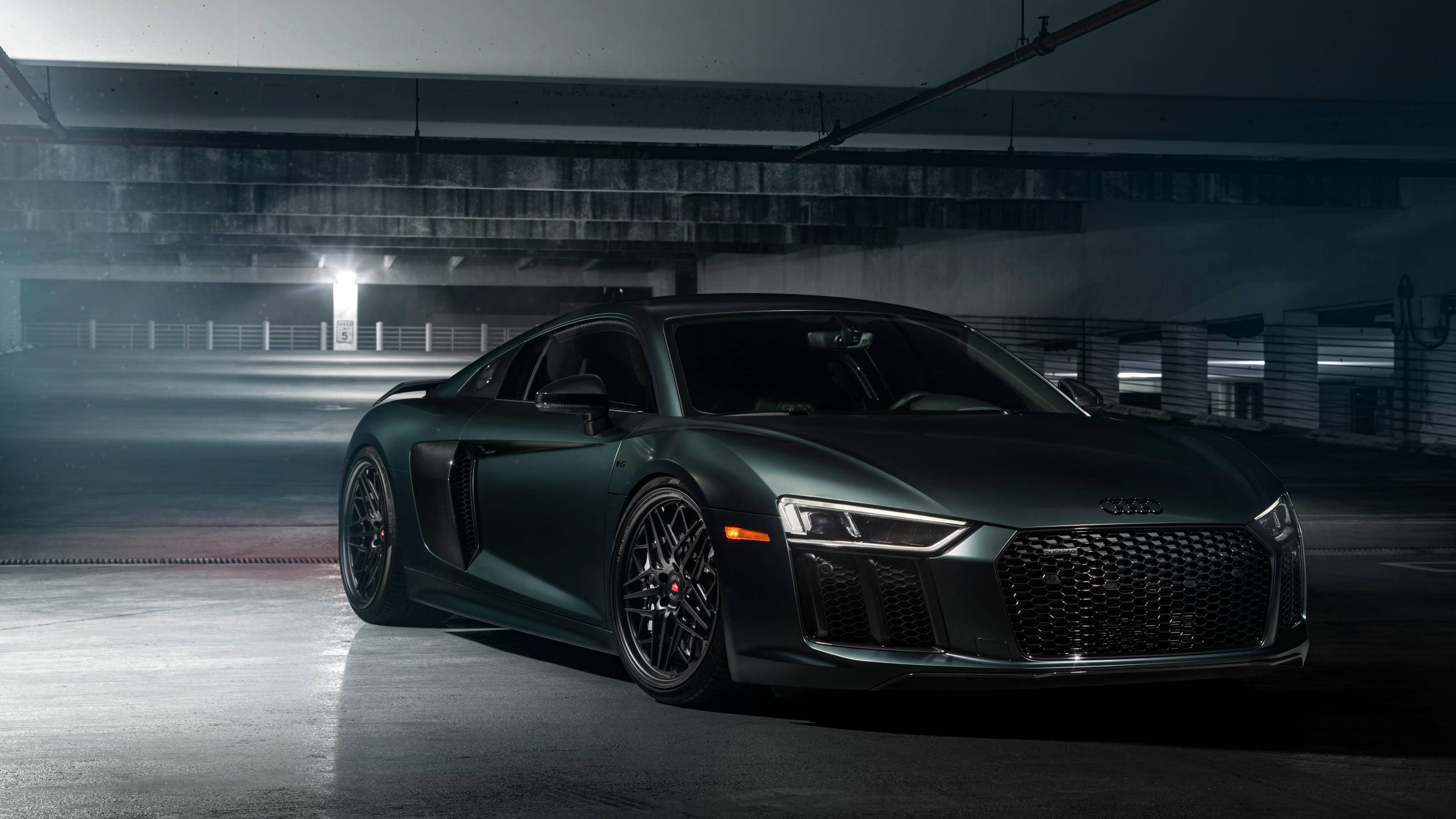 R8 桌布 壁紙 — 一架時尚的消光綠色奧迪R8跑車停放在燈光昏暗的地下停車場，帶有戲劇性的燈光效果。